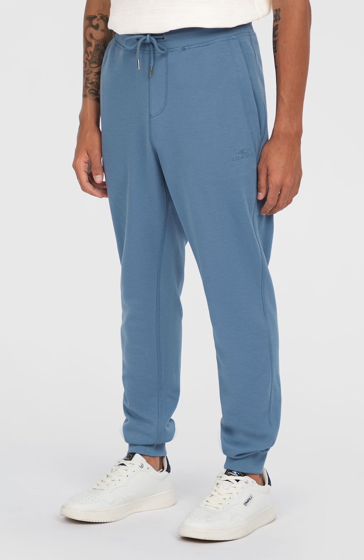 Small Logo Jogginghose für Herren in Blau, schräge Ansicht am Model mit elastischen Beinabschlüssen