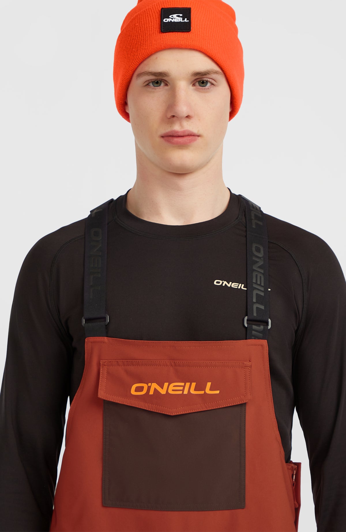 FWC'Peak Bib Skihose für Herren, orange, Nahaufnahme des Latzes mit Logo-Print und Trägern