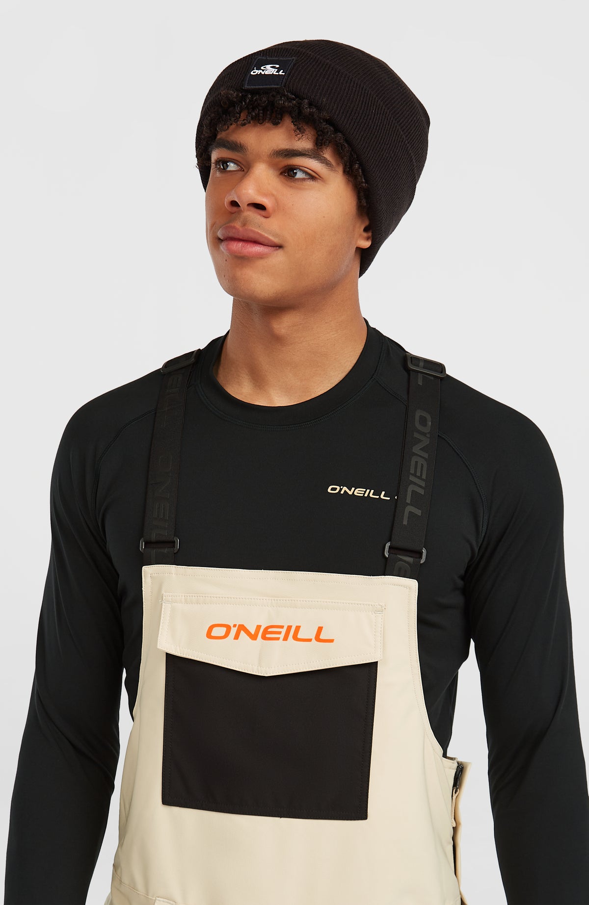 FWC'Peak Bib Skihose für Herren, beige, Nahaufnahme am Model mit großer aufgesetzter Fronttasche am Latz