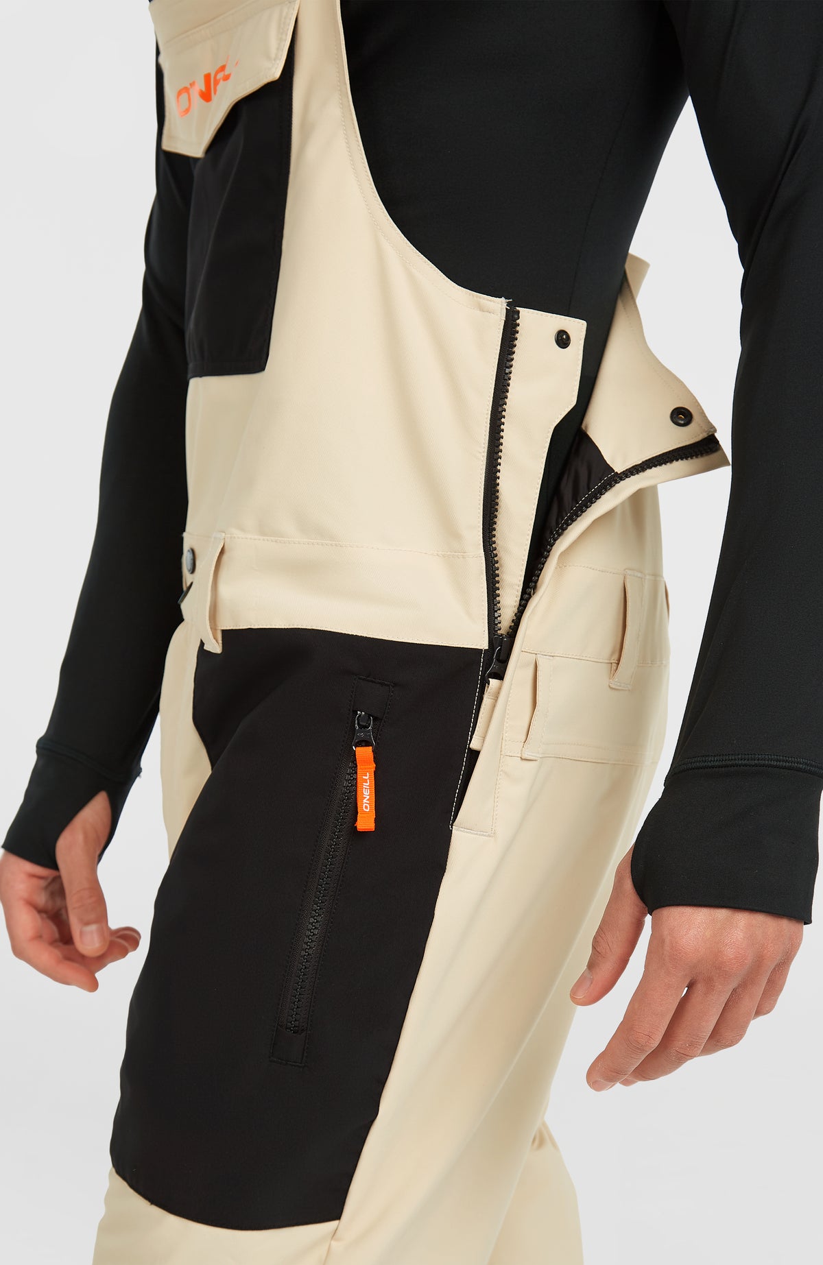 FWC'Peak Bib Skihose für Herren, beige, Nahaufnahme am Model mit seitlichem Reißverschluss und Logo-Puller