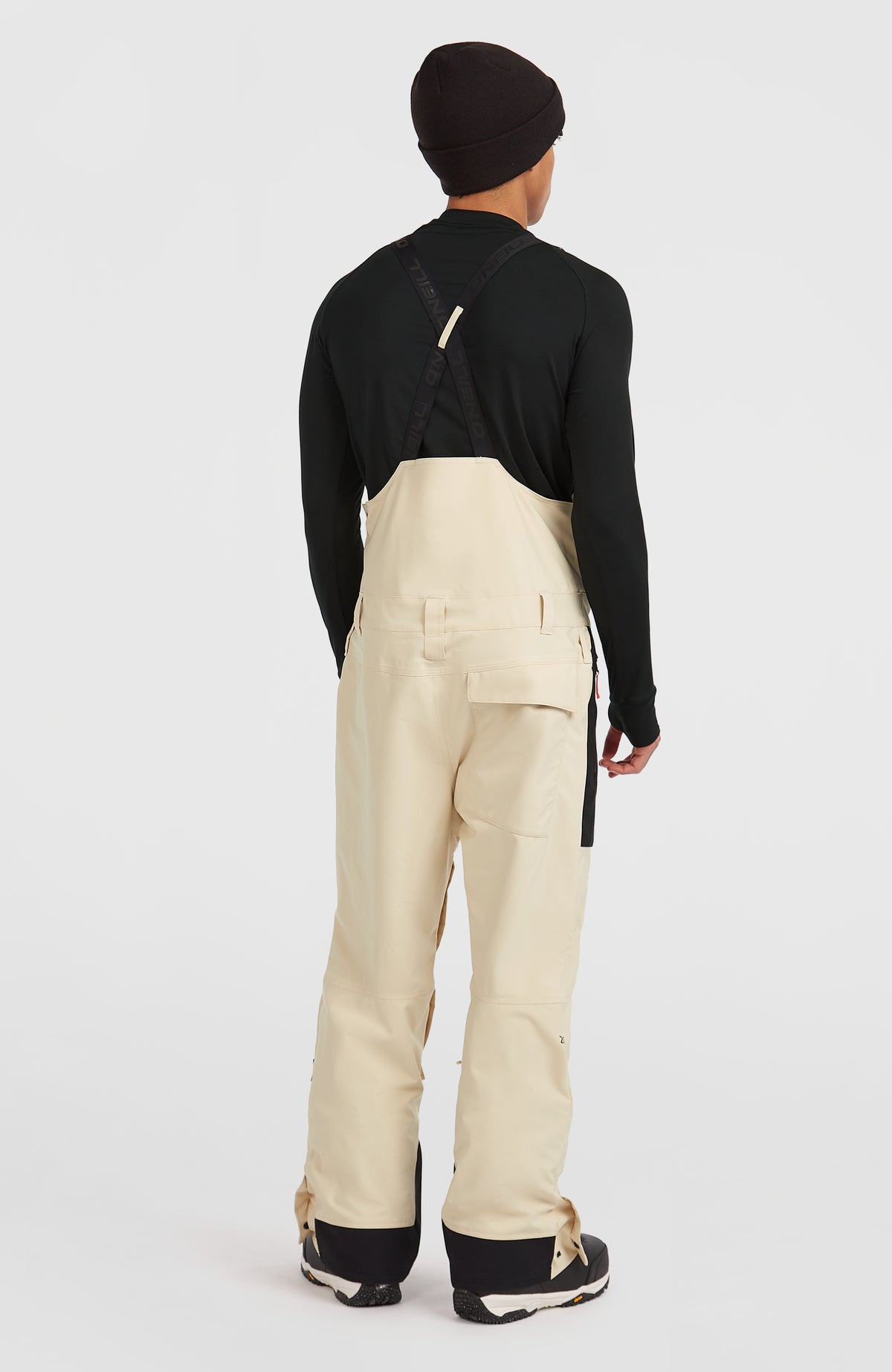 FWC'Peak Bib Skihose für Herren, beige, Rückansicht am Model mit gekreuzten Trägern und geknöpfter Rückentasche