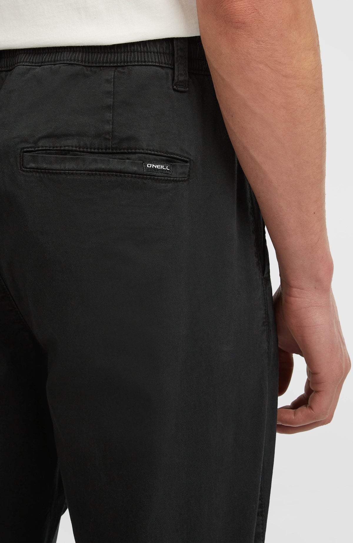 Nahaufnahme der schwarzen Essentials Chino-Hose für Herren, Gesäßtasche mit dezentem Logo-Label