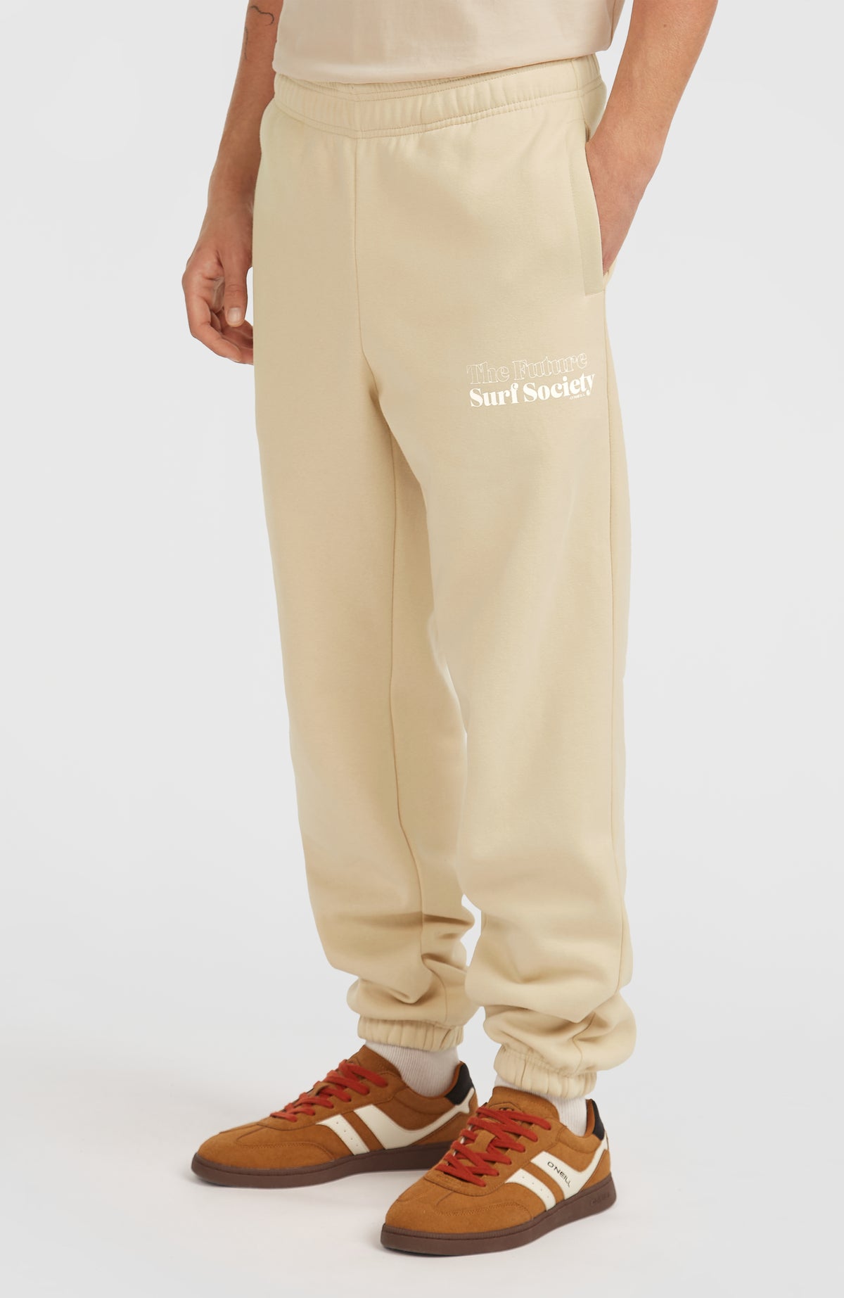 Future Surf Society Jogginghose für Herren, beige mit Logo-Print in Weiß, Dreiviertelansicht am Model mit Seitentasche