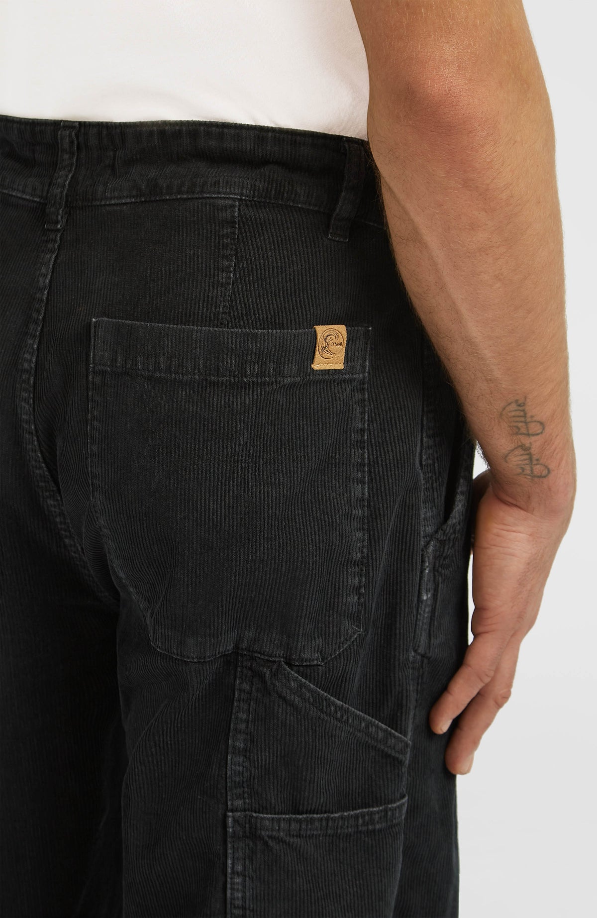 Nahaufnahme der aufgesetzten Gesäßtasche mit kleinem Logo-Label an der schwarzen O'Riginals Carpenter Hose