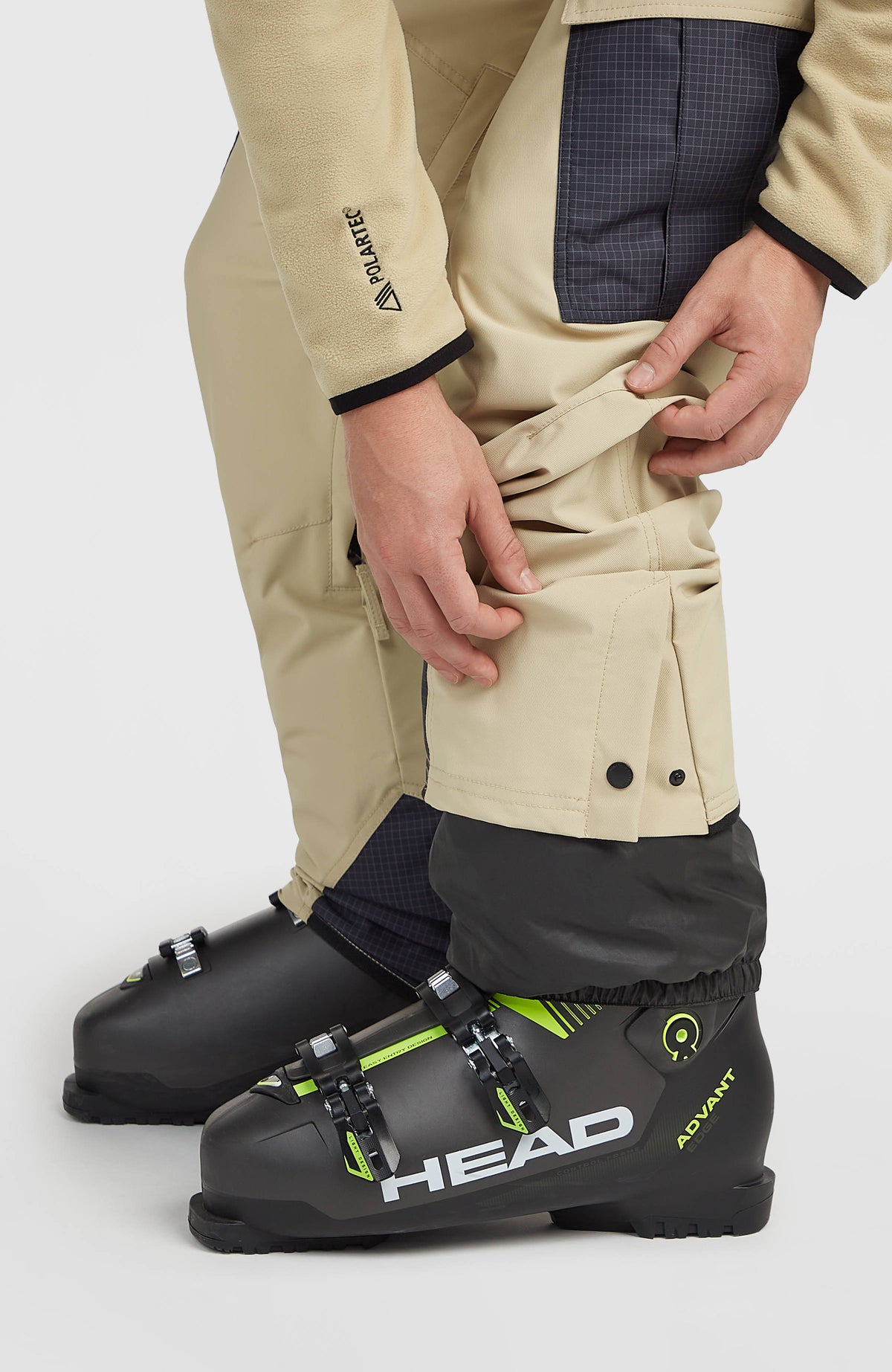 Nahaufnahme des Saums mit Schneefang und Druckknöpfen der beigen FWC'Peak Cargo-Skihose