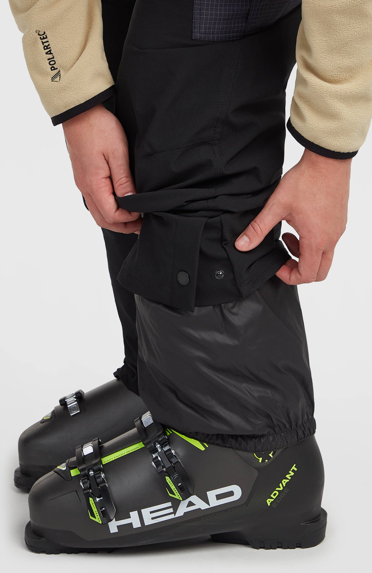 Nahaufnahme von verstellbarem Saum mit Druckknopf und Schneefang der schwarzen FWC'Peak Cargo-Skihose
