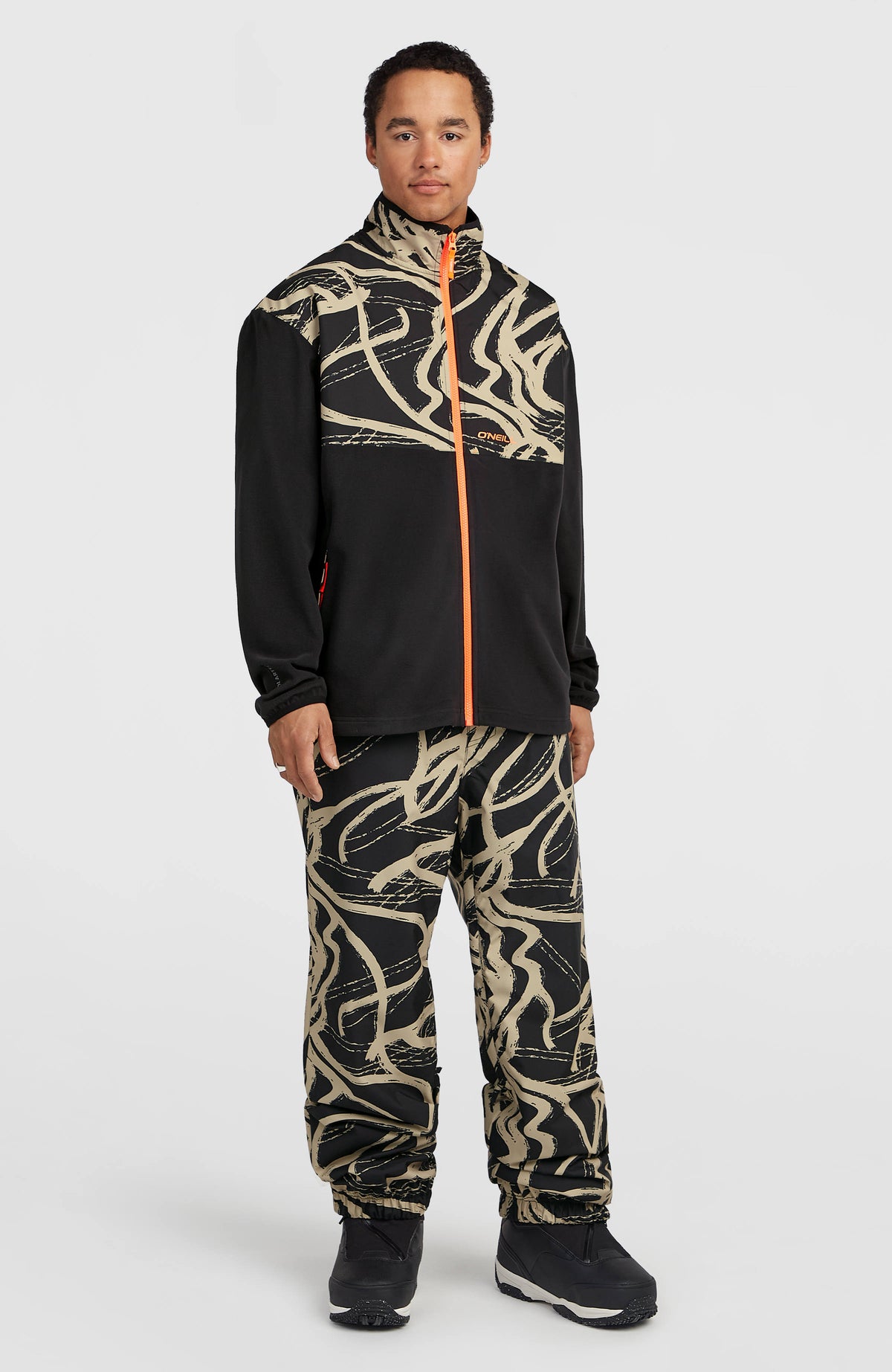 FWC Oversized Ski- und Snowboardhose für Herren, beige mit Grafikmuster in Schwarz, Ganzkörperansicht am Model