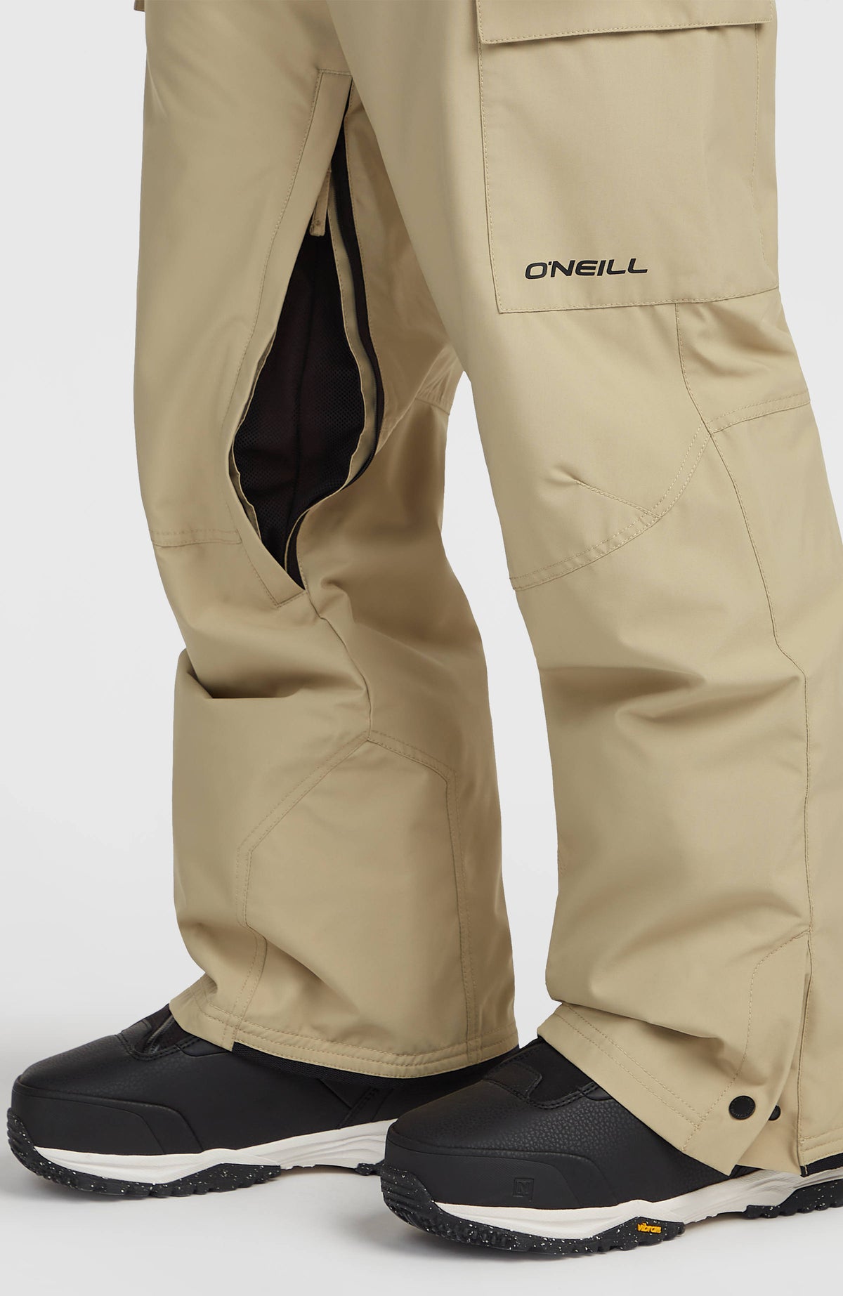 Nahaufnahme der beigen FWC'Cruz Cargo-Skihose am Model mit geöffnetem Belüftungsreißverschluss