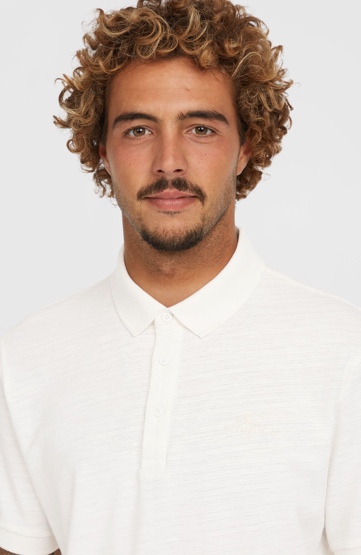 Nahaufnahme von Kragen und Knopfleiste des weißen Slub Small Logo Poloshirt am Model