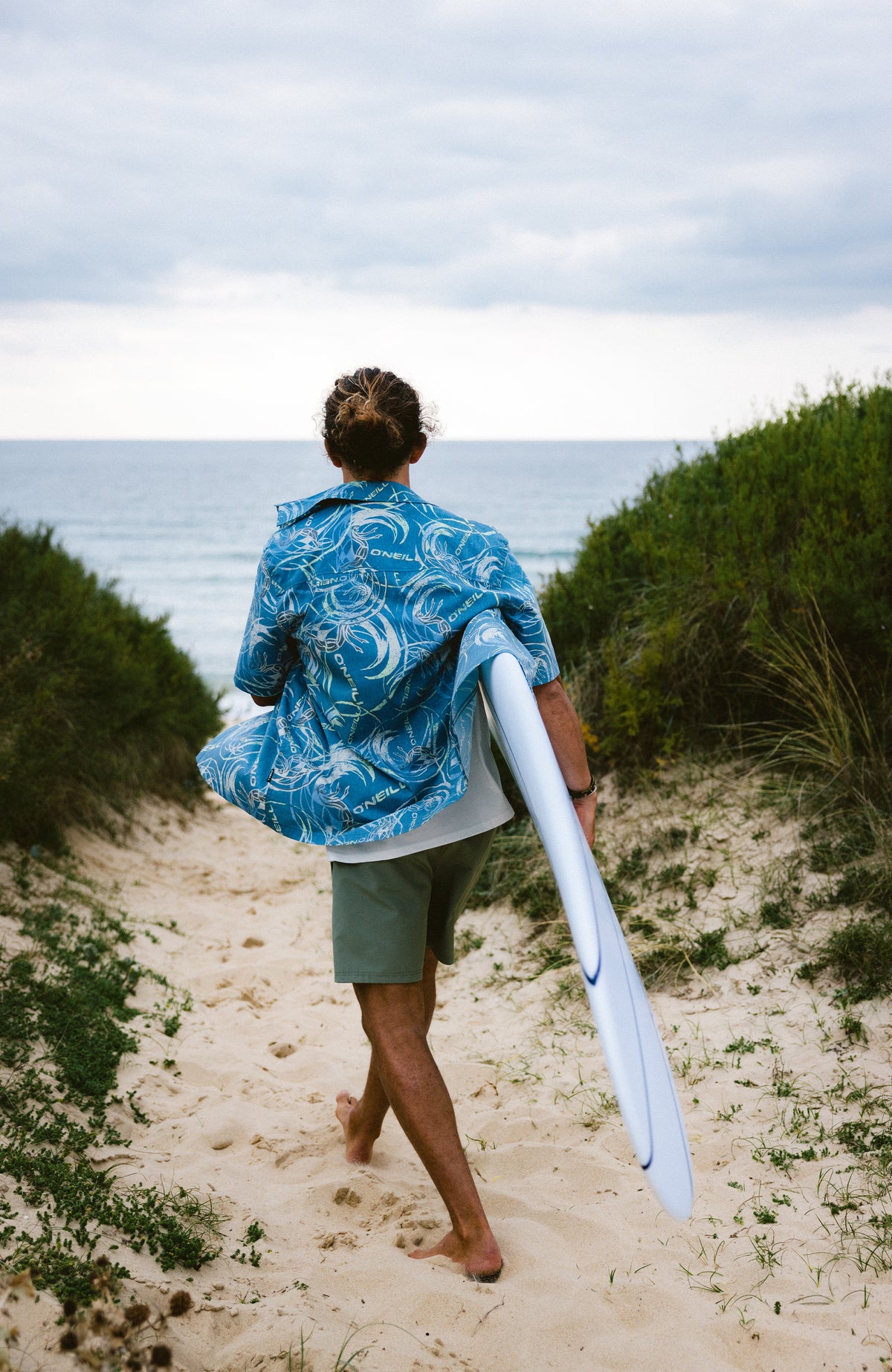 O'Riginals UPF 50+ Kurzarmhemd für Herren, blau mit Grafikmuster in Gelb und Weiß, Rückansicht am Strand