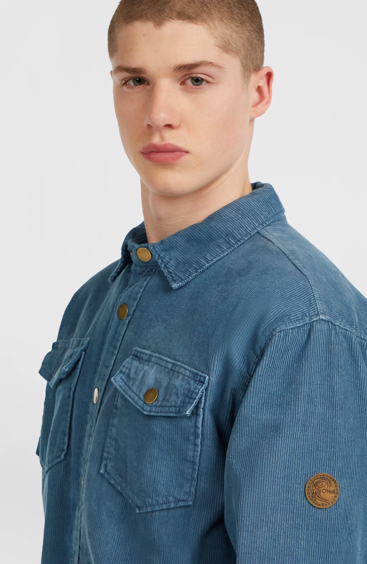 O'Riginals Cord-Overshirt für Herren, blau, schräge Ansicht mit Logo-Badge am Ärmel am Model