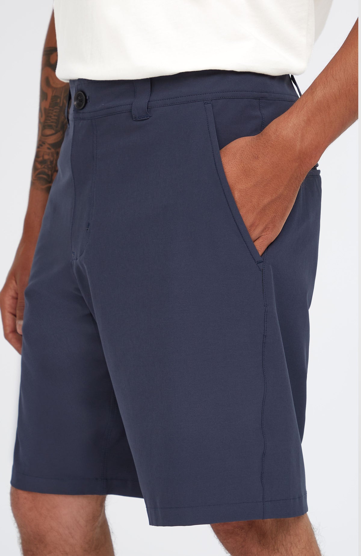 Nahaufnahme der blauen Hybrid 19" Chino-Shorts am Model, Detailansicht der seitlichen Eingrifftasche