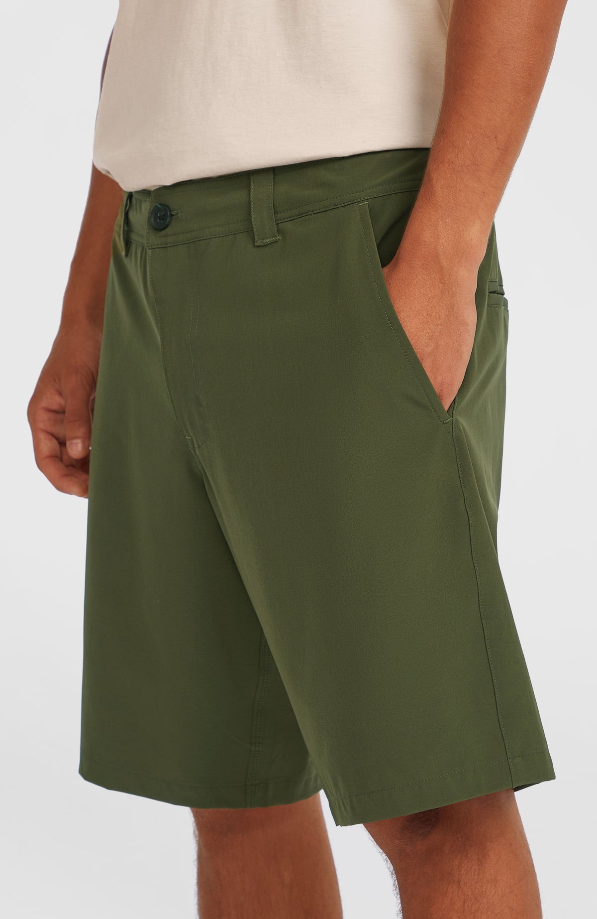 Grüne Hybrid 19" Chino-Shorts für Herren, seitliche Nahaufnahme am Model mit Fokus auf die Eingrifftasche