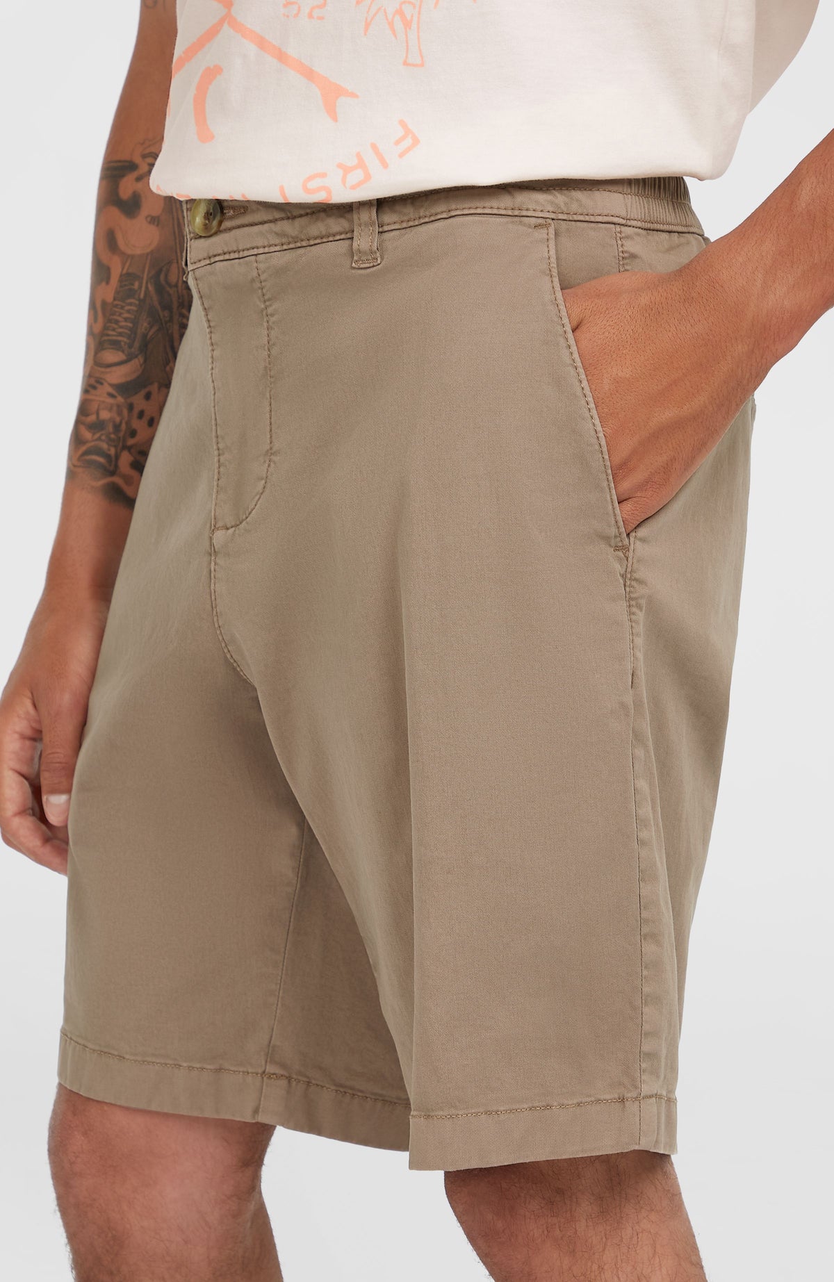 Nahaufnahme von Bund, Knopf und Seitentasche der braunen Essentials Chino-Shorts