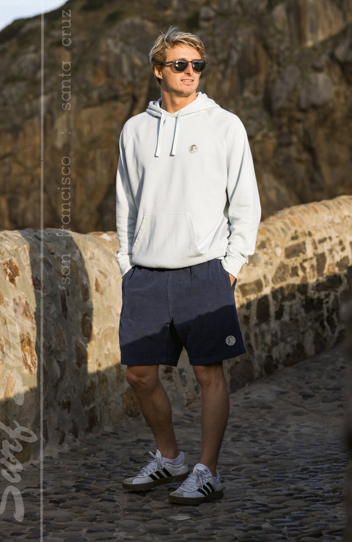 O'Riginals Cord-Shorts für Herren in Blau, getragen am Model auf einem Steinweg vor Felswand