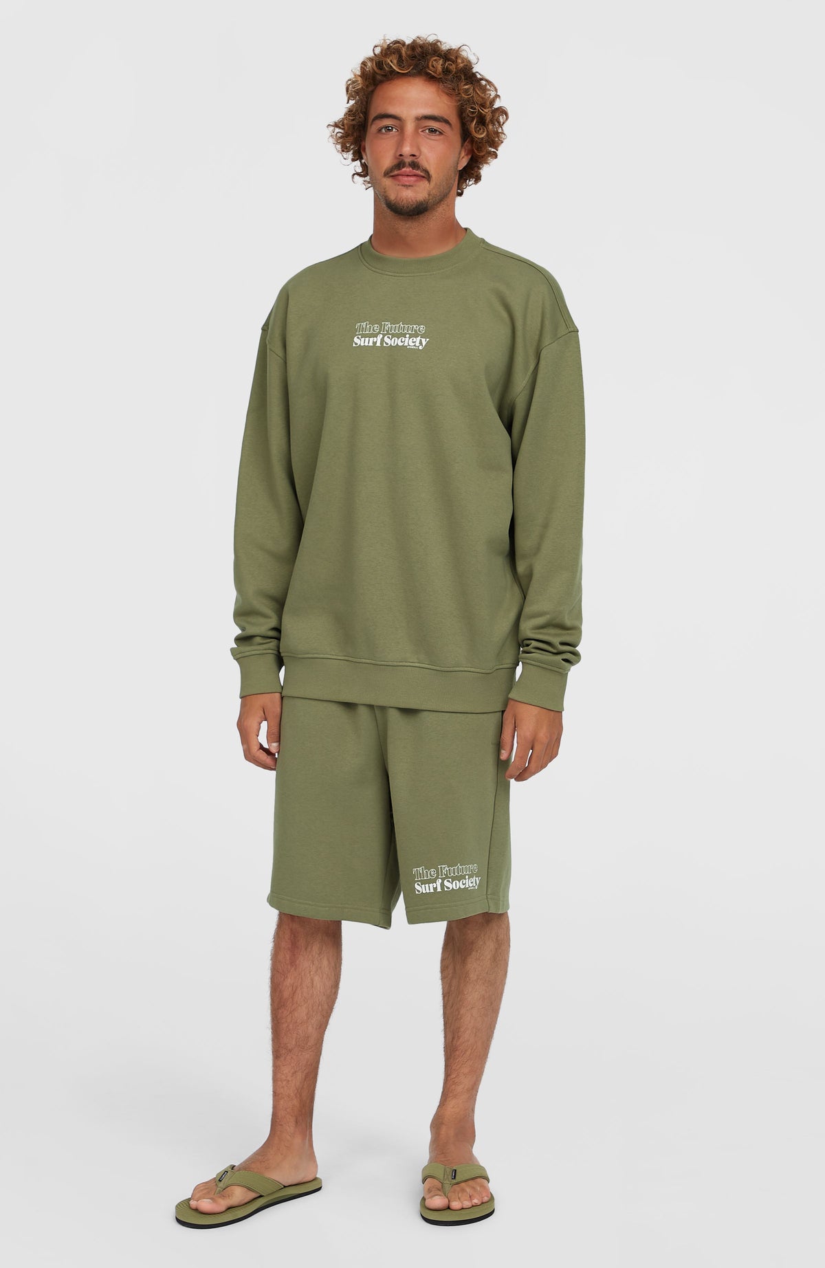 Future Surf Society Crew Sweatshirt für Herren, grün mit Logo-Print in Weiß, getragen am Model in Ganzkörperansicht