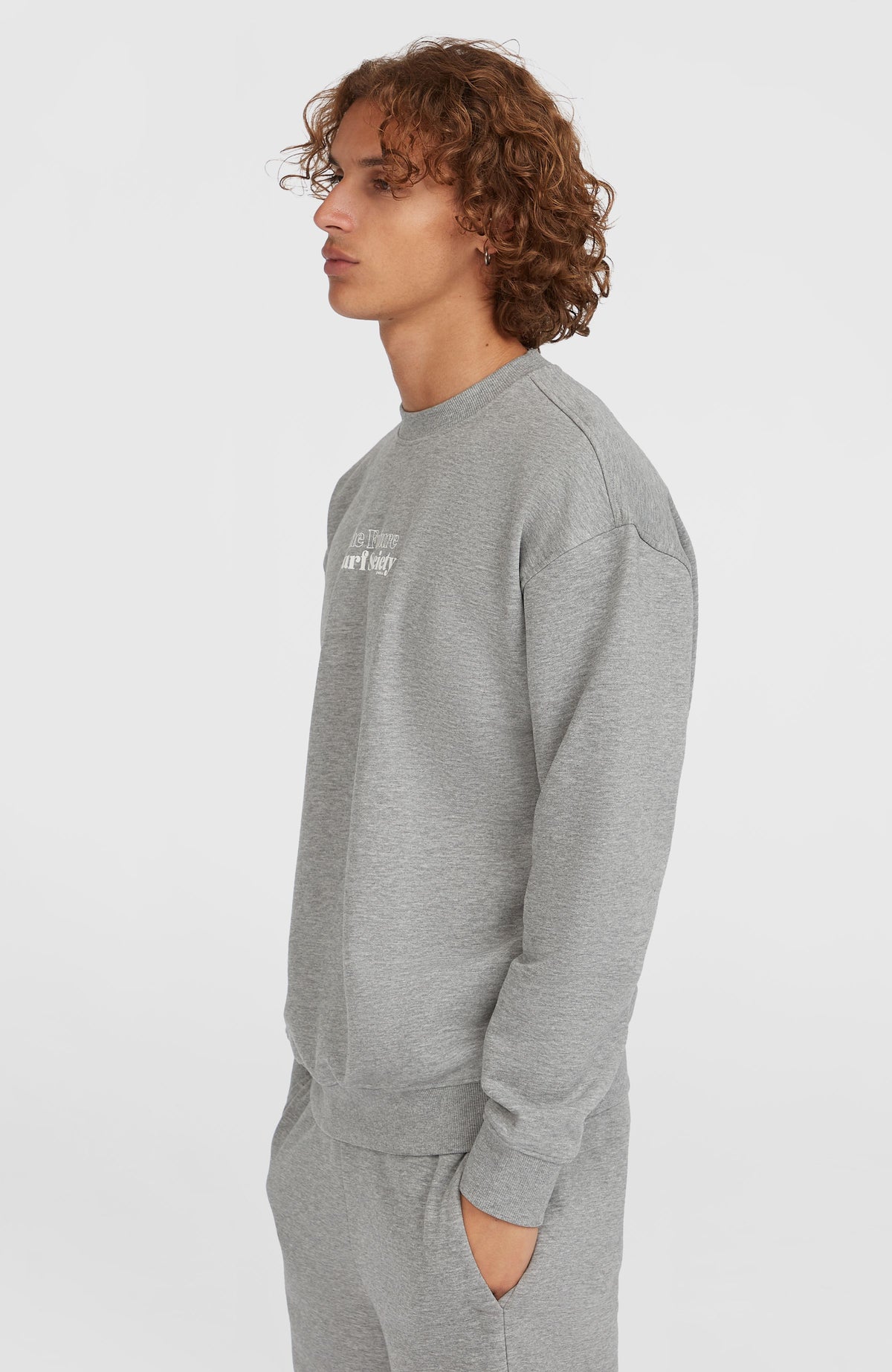 Future Surf Society Crew Sweatshirt für Herren, grau mit Logo-Print in Weiß, Seitenansicht am Model mit Bündchen