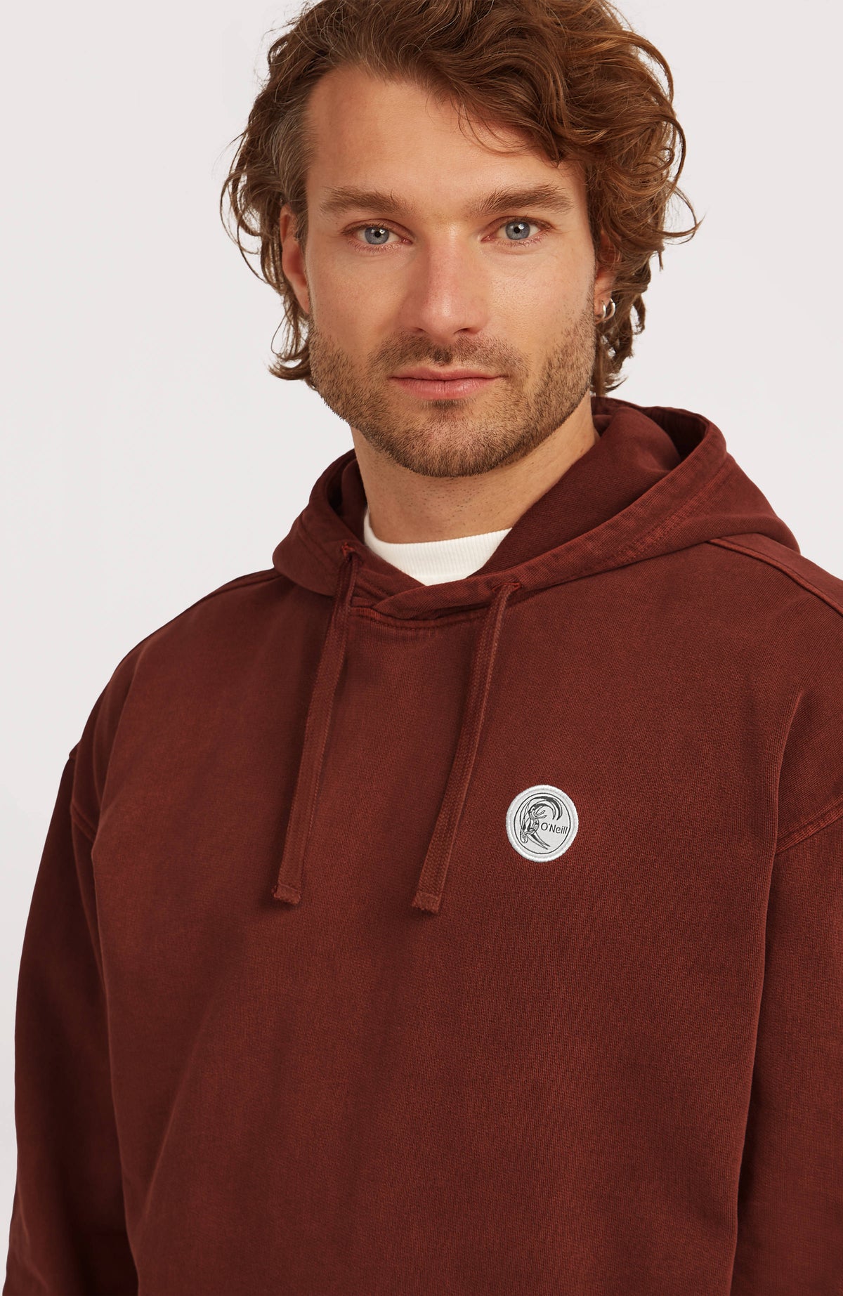 O'Riginals Hoodie für Herren, braun, Nahaufnahme am Model mit Kordelzug und Logo-Badge