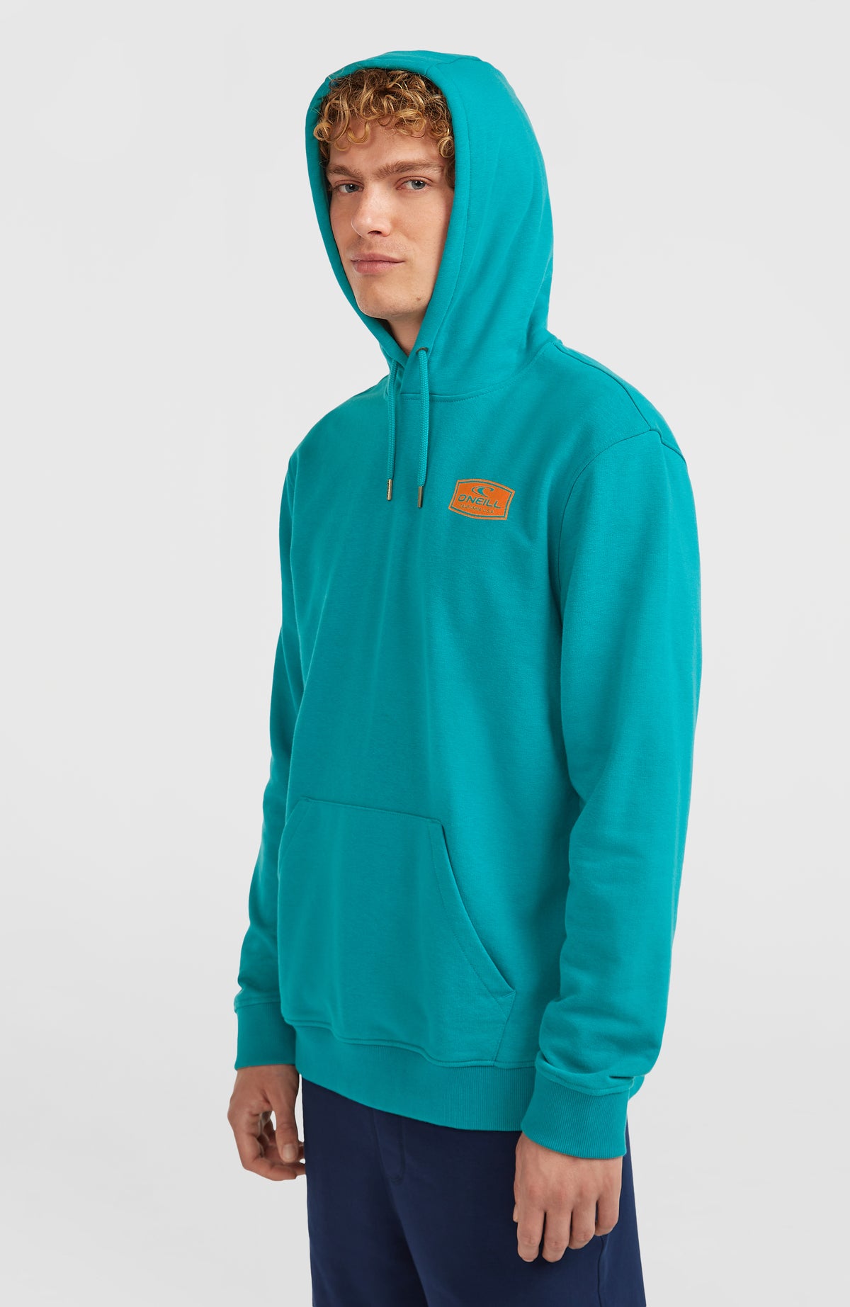 Graphic Hoodie für Herren, blau mit Logo-Patch in Orange, Halbprofil am Model mit aufgesetzter Kapuze