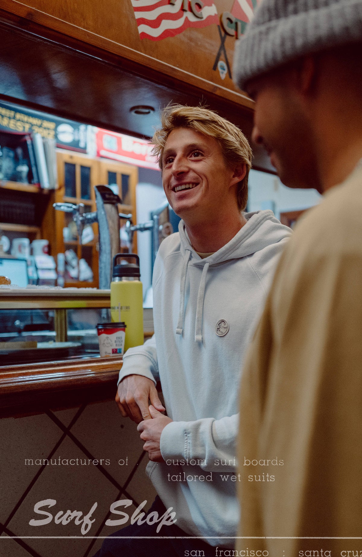 O'Riginals Badge Hoodie für Herren, blau, in einer Bar getragen am Model, runder Logo-Badge