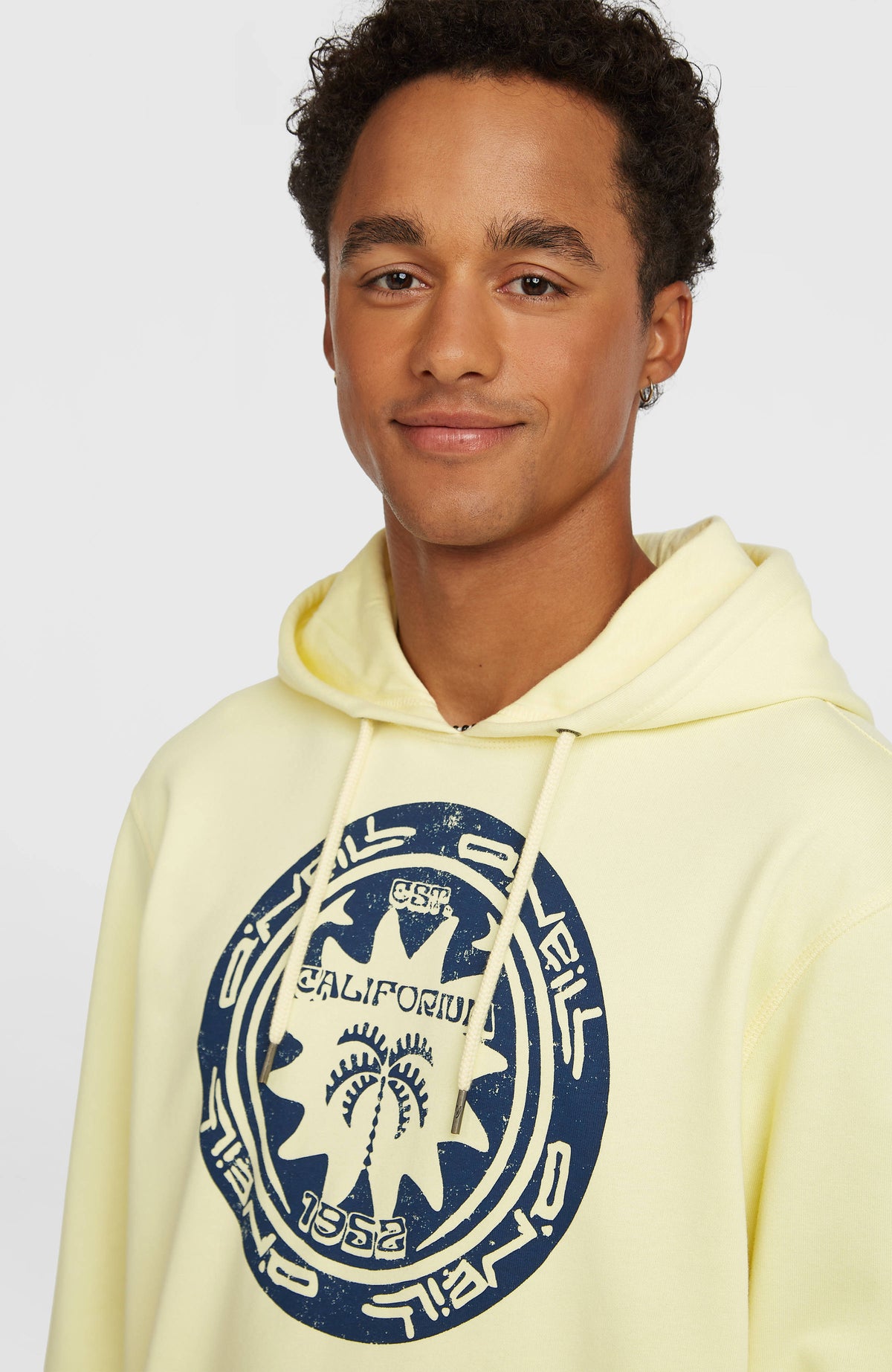 Must-Have Graphic Hoodie, gelb mit Grafik-Print in Dunkelblau, Nahaufnahme von Kapuze und Kordelzug am Model