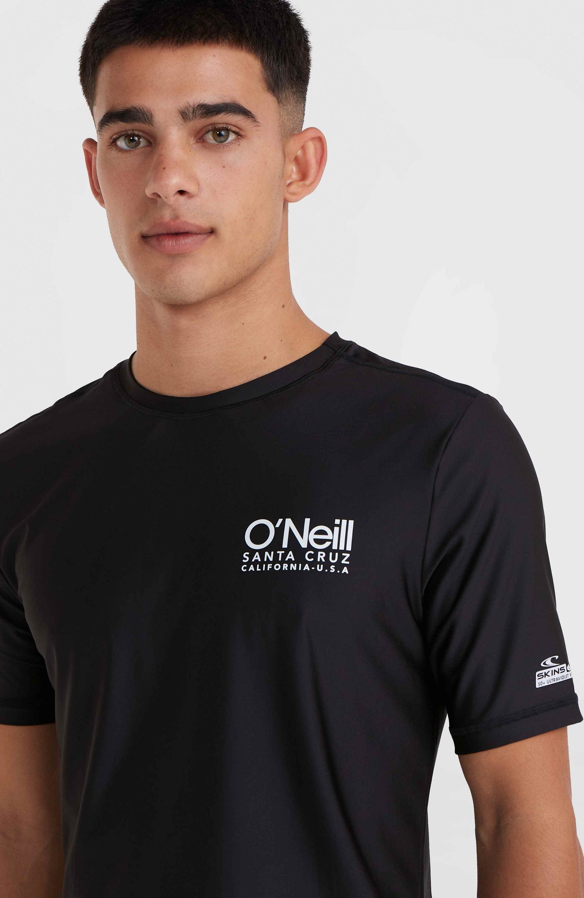 Essentials Cali Shortsleeve-Schwimmshirt, schwarz, Nahaufnahme am Model mit weißem Logo-Print auf der Vorderseite