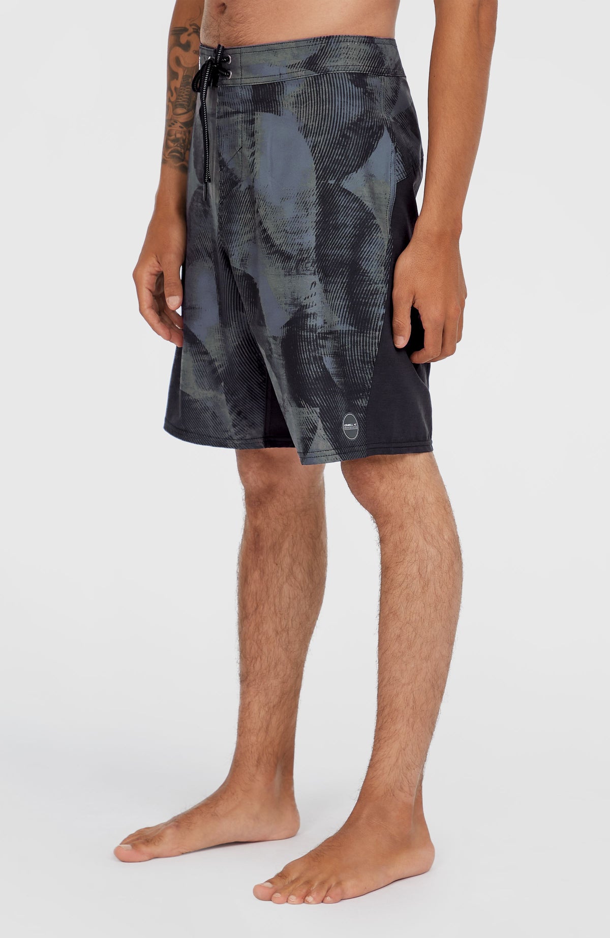 Tech Enduro 20'' Boardshorts für Herren, grün mit Grafikmuster in Schwarz, Seitenansicht am Model mit Logo-Patch