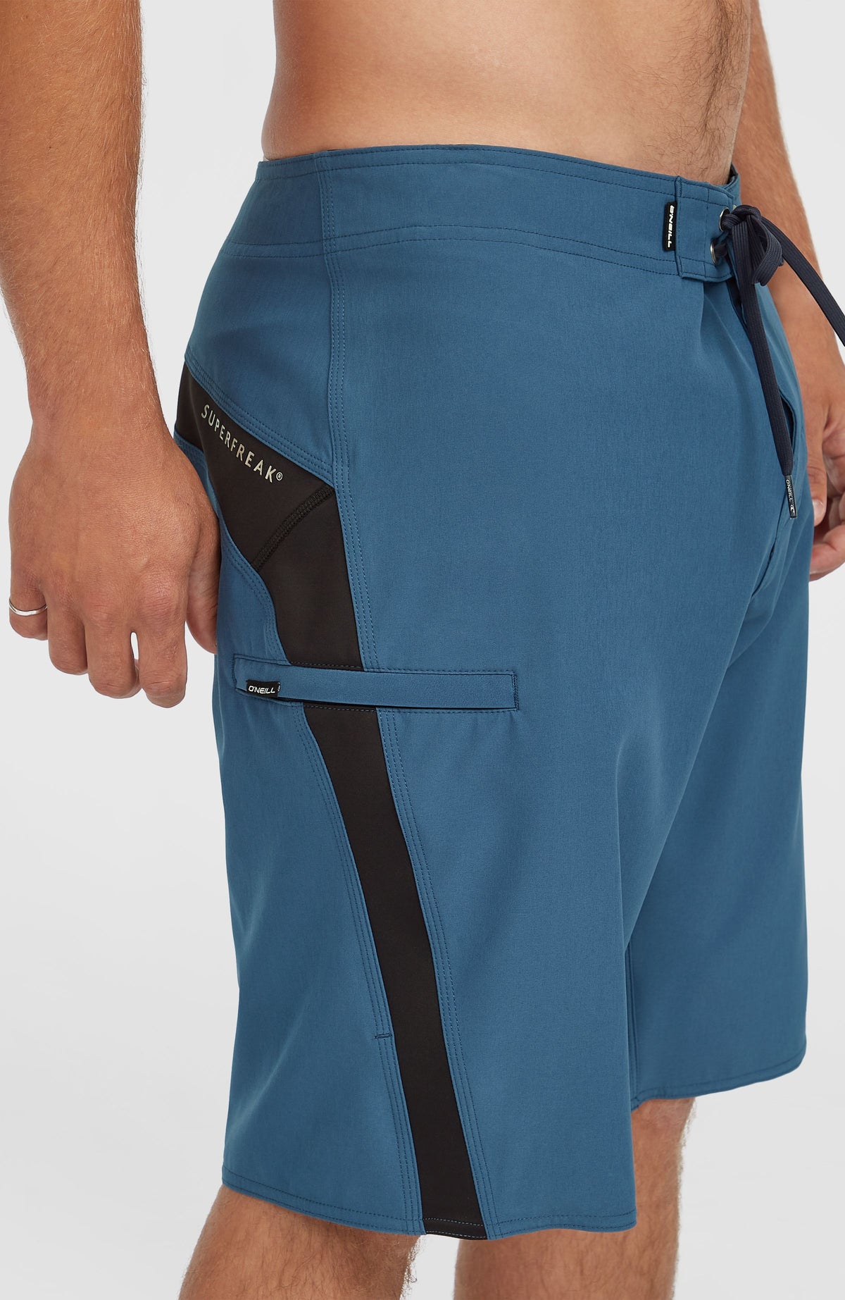 Nahaufnahme der blauen Superfreak Solid 21'' Boardshorts für Herren mit Seitentasche und Kontrasteinsatz