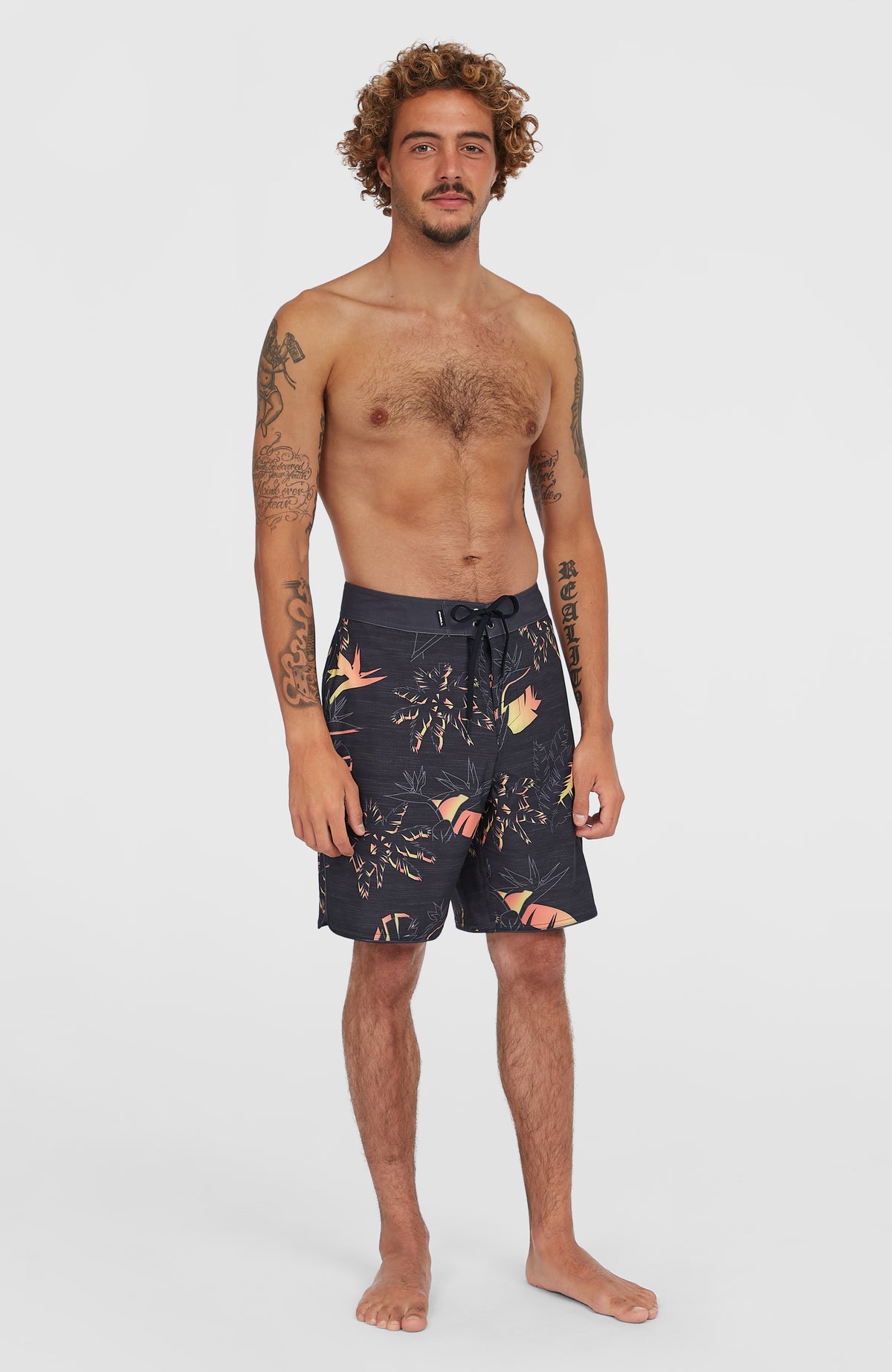 Hyperfreak Mysto Boardshorts für Herren, schwarz mit Palmenmuster in Orange und Gelb, Ganzkörperansicht am Model