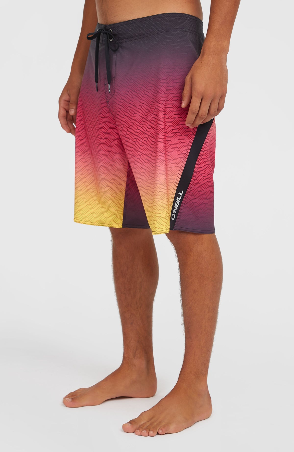 Superfreak Mysto 20'' Boardshorts, pink mit Farbverlauf in Schwarz und Gelb, Seitenansicht mit Logo-Streifen am Model