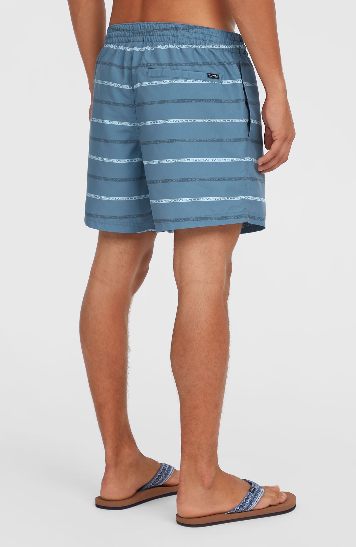 Blaue Cali First 15'' Badehose für Herren mit Streifenmuster, Rückansicht am Model mit Gesäßtasche