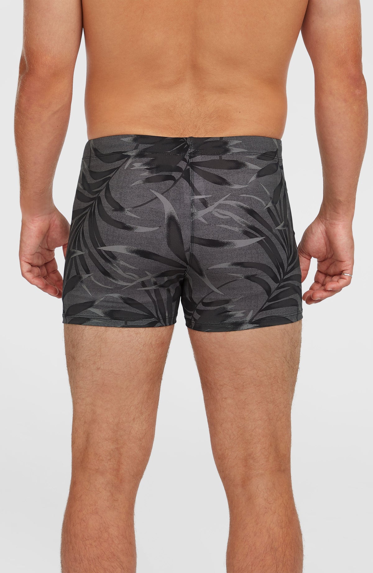 Essentials Floral Racer Badehose für Herren, schwarz mit Blättermuster in Grau, getragen am Model von hinten