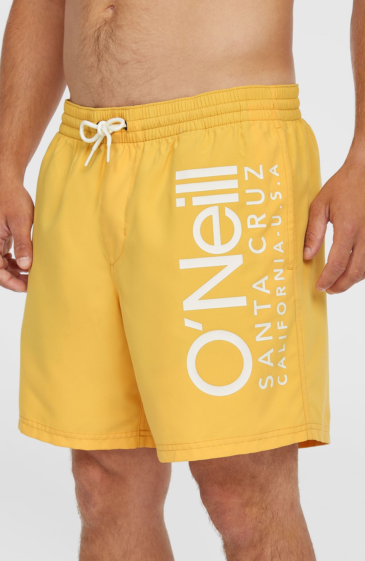 Nahaufnahme der gelben Original Cali 16'' Badehose mit Logo-Print in Weiß, elastischer Bund und Kordelzug