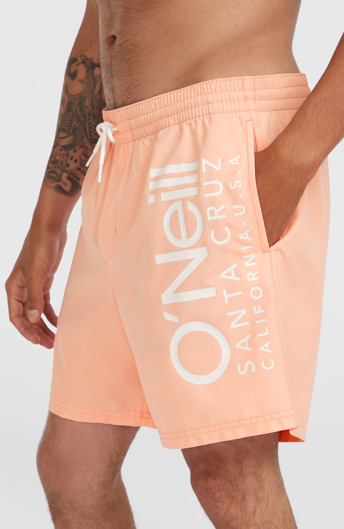 Original Cali 16'' Badehose, pink mit Logo-Print in Weiß, Nahaufnahme von Seitentasche und Bund am Model