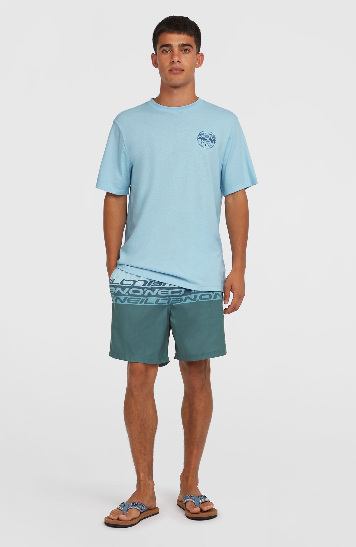 Cali Stripe 16'' Badehose für Herren, blau mit Logo-Print in Blau, getragen am Model mit T-Shirt, Ganzkörperansicht