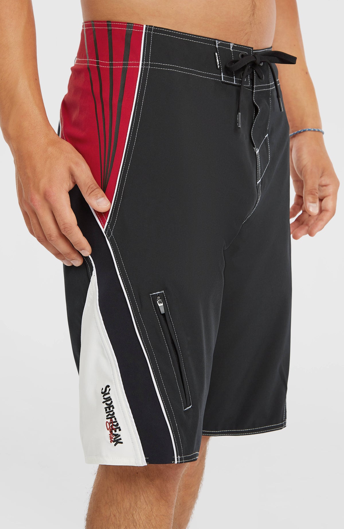Nahaufnahme der Reißverschlusstasche am Hosenbein der schwarzen Superfreak Re-Issue Boardshorts
