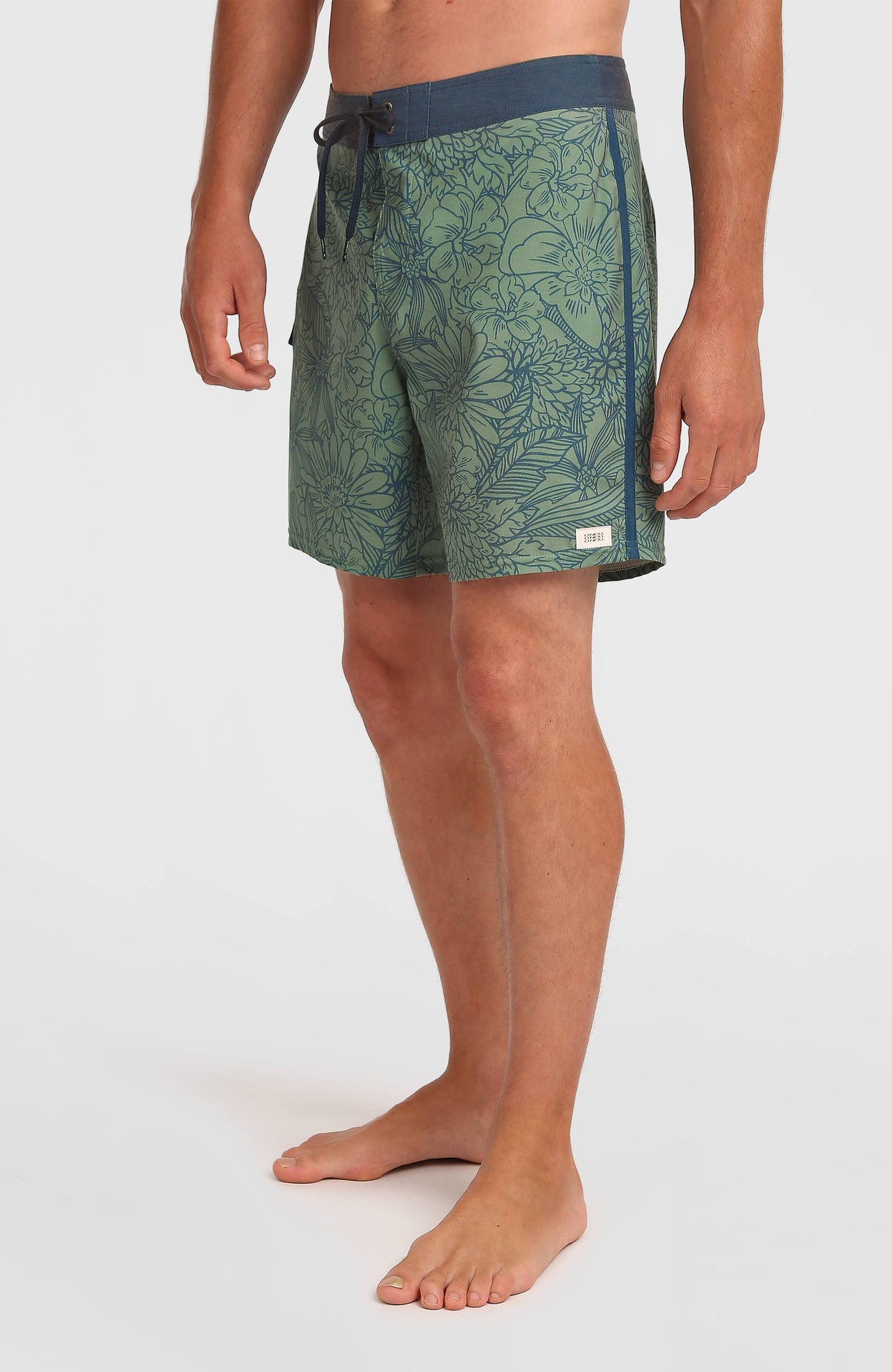 Lineup 18'' Boardshorts für Herren, grün mit Blumenmuster in Dunkelblau, Halbprofil am Model mit Logo-Patch am Saum