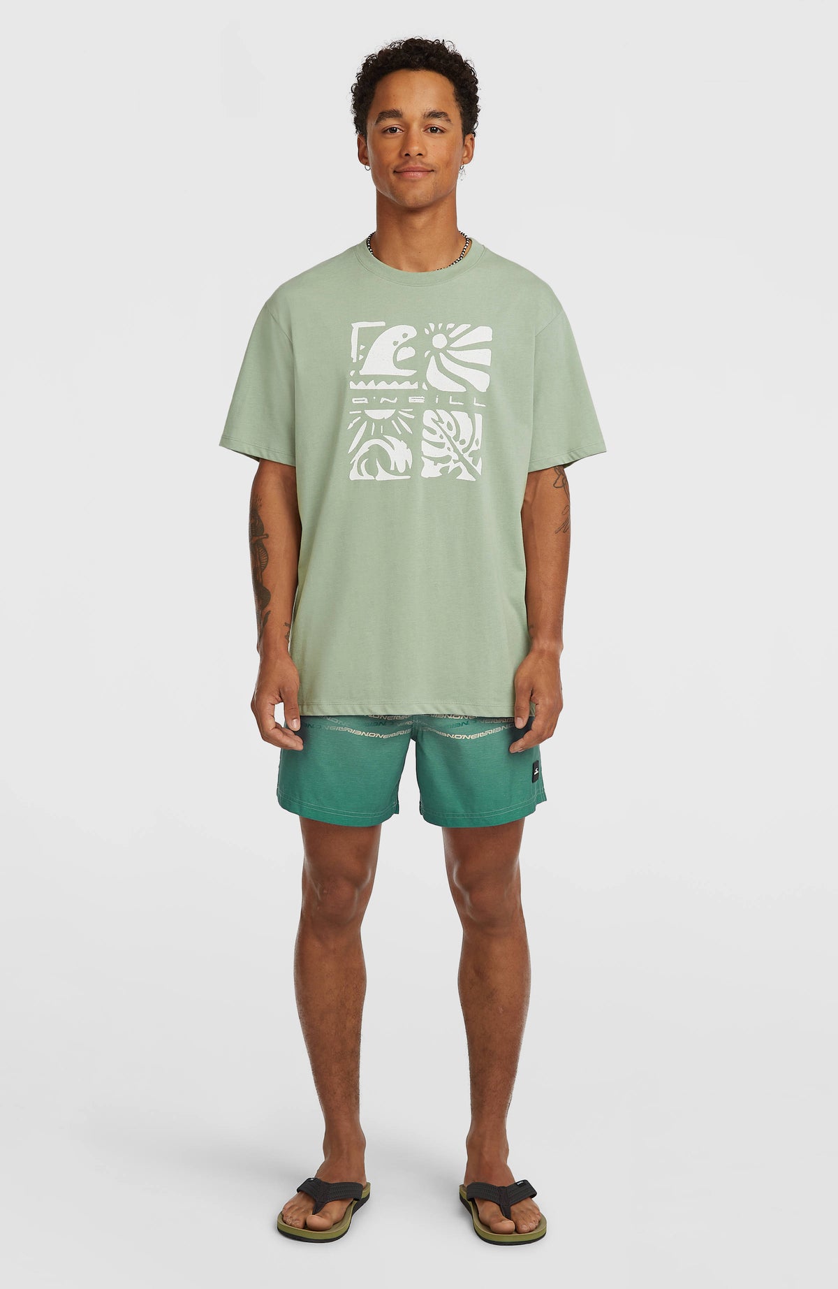 First 15'' Badehose für Herren, grün mit Logo-Print in Beige, Ganzkörperansicht am Model mit T-Shirt