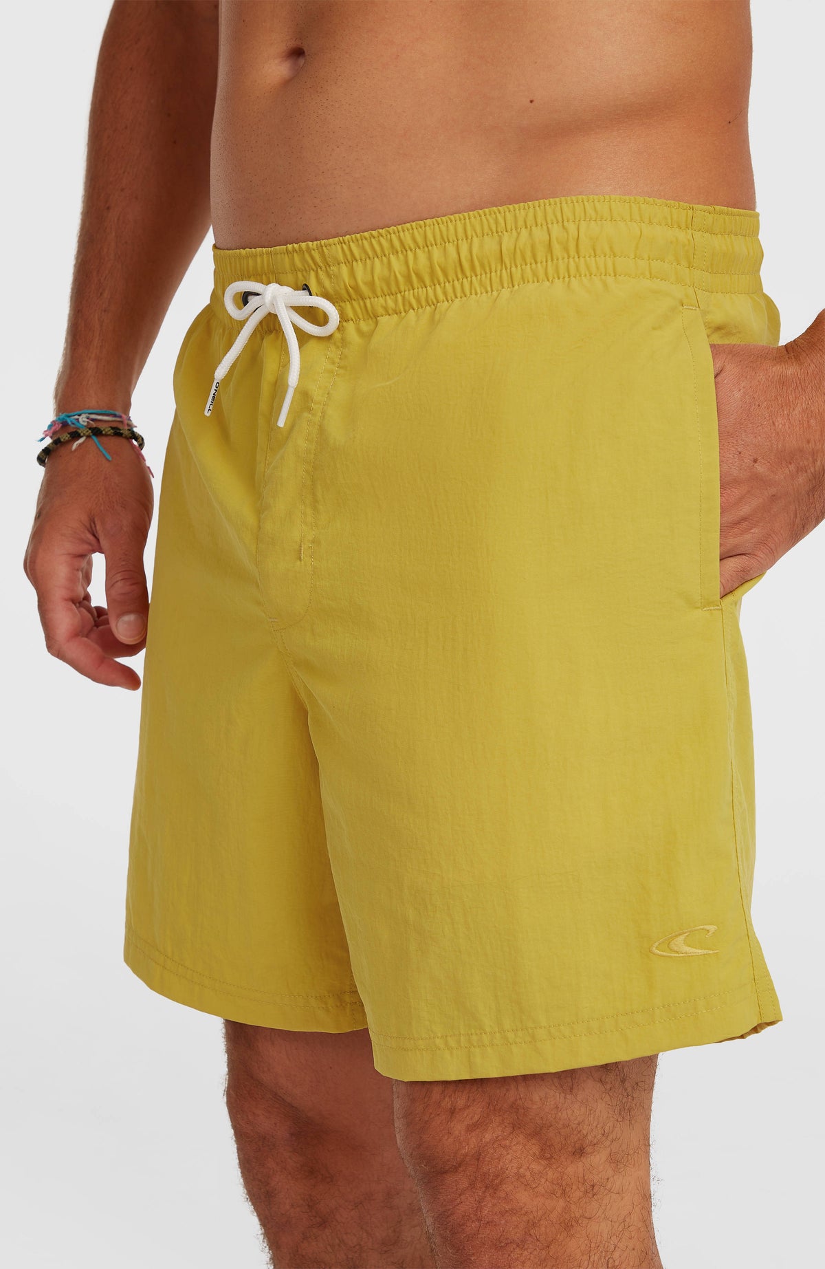 Vert 16'' Badehose für Herren, gelb, Nahaufnahme am Model mit weißem Kordelzug und Logo-Stickerei am Saum