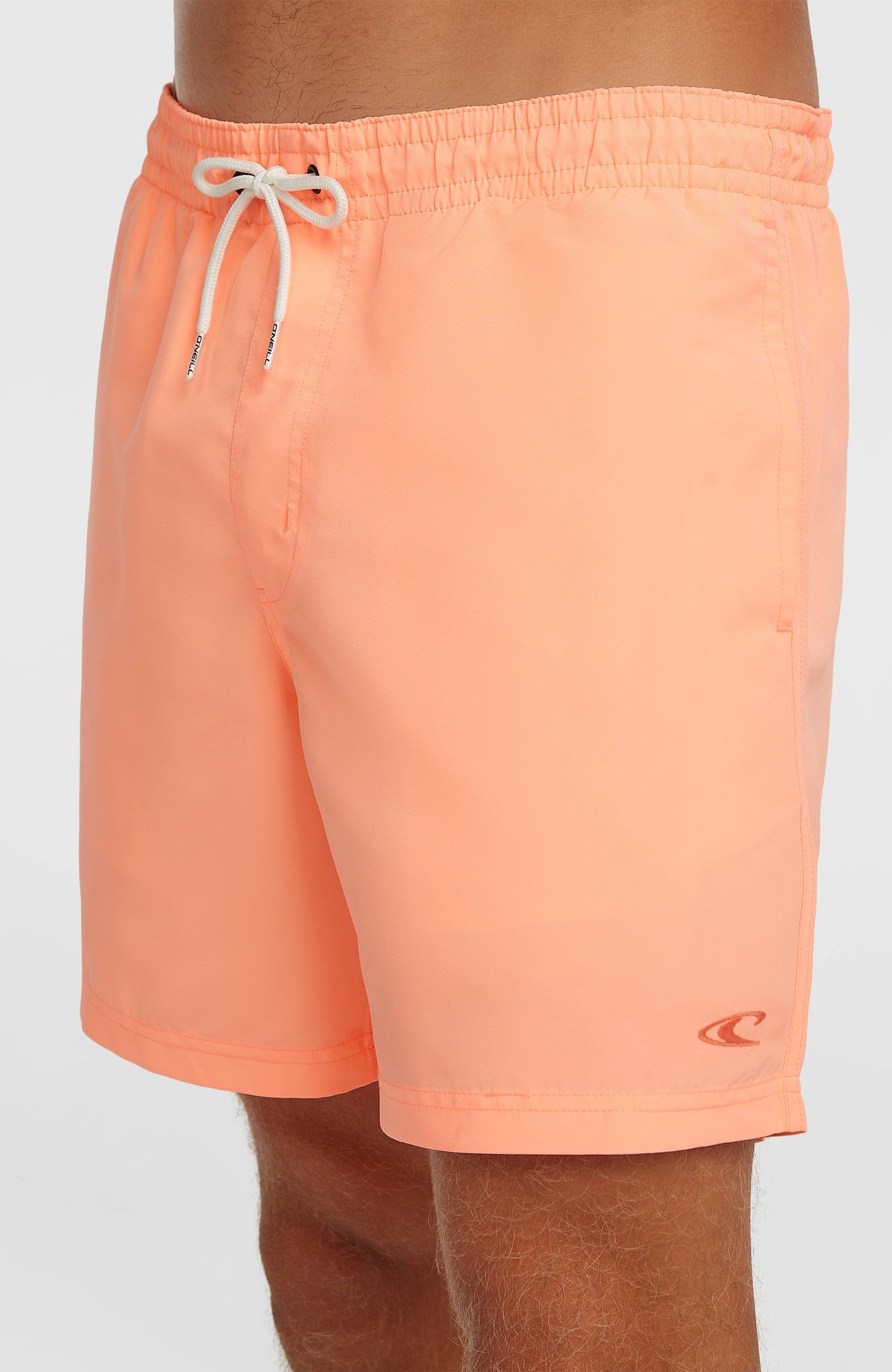 Vert 16'' Badehose für Herren, orange, Nahaufnahme am Model mit kleinem Logo-Detail am Saum