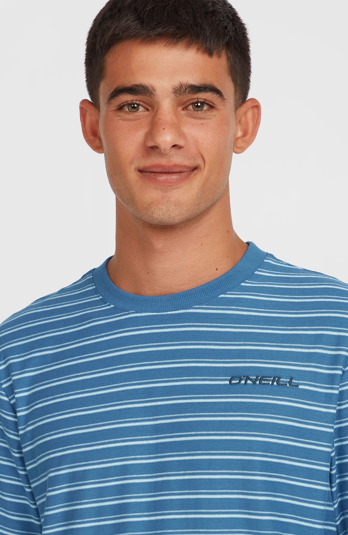 Yarn Stripe T-Shirt, blau mit Streifenmuster, Nahaufnahme von Rundhalsausschnitt und Logo-Schriftzug am Model
