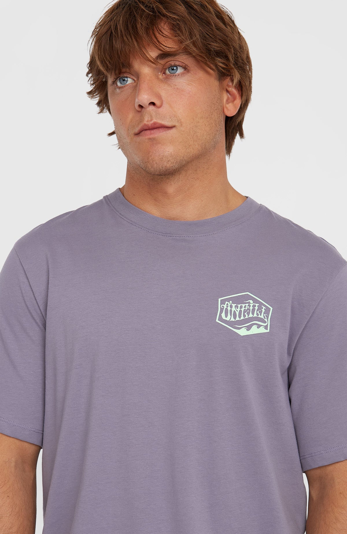 Nahaufnahme von Rundhalsausschnitt und Logo-Print in Mintgrün auf der Brust des lila Box Logo T-Shirt am Model