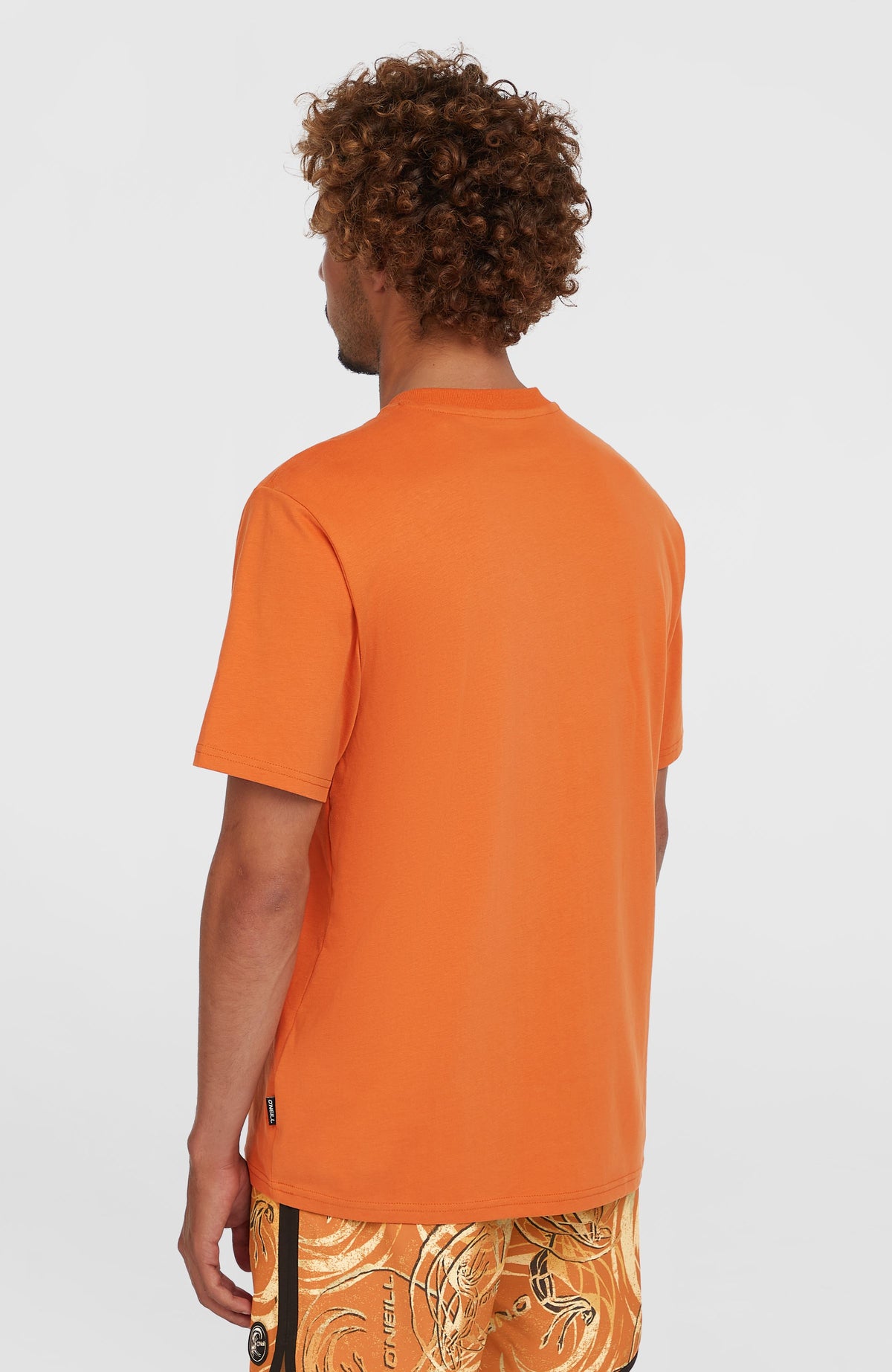 O'Riginals Badge T-Shirt für Herren, orange, Rückansicht am Model mit kleinem Webetikett an der Seitennaht