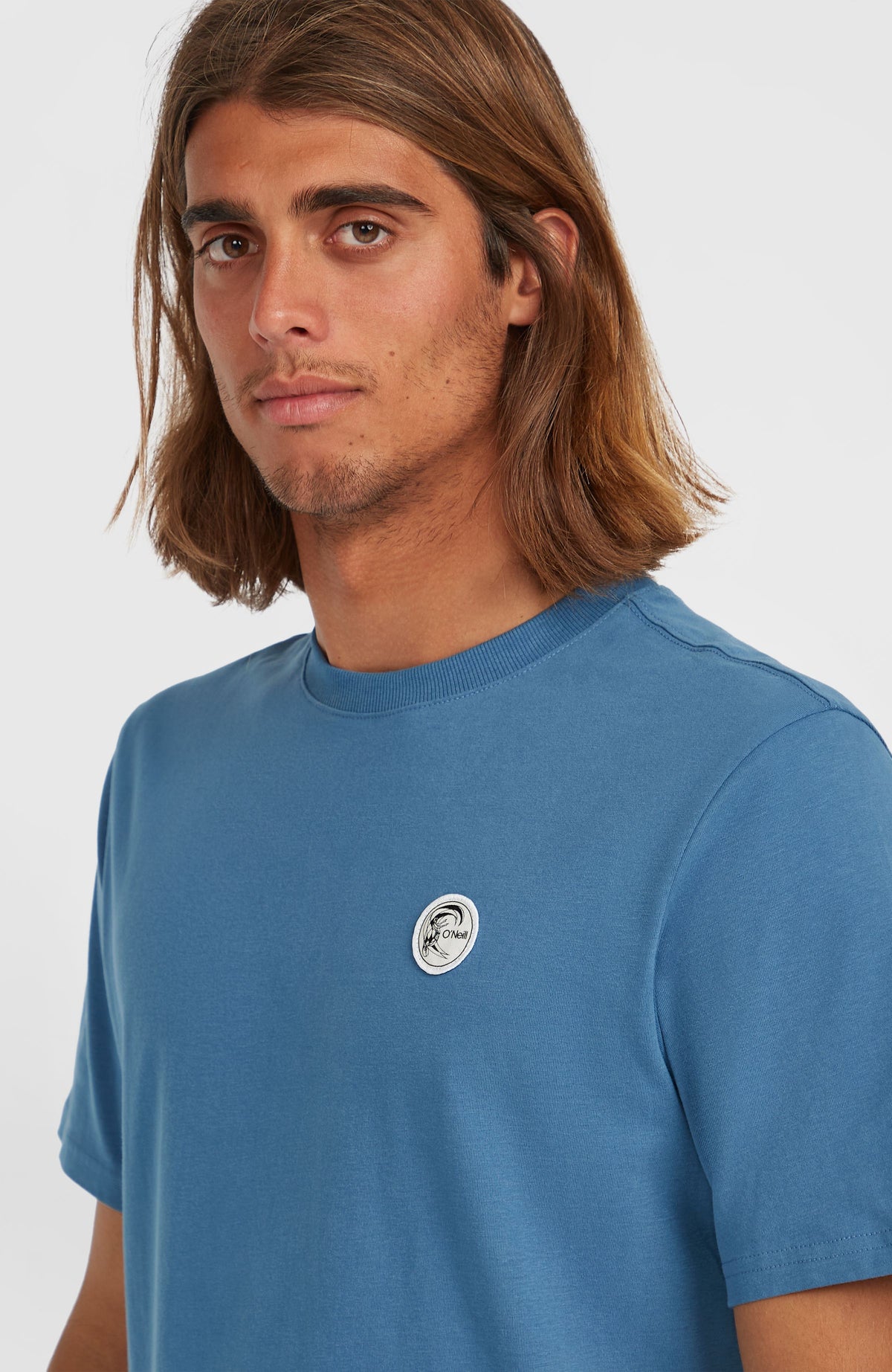 O'Riginals Badge T-Shirt, blau, Nahaufnahme des runden Logo-Badges am Model