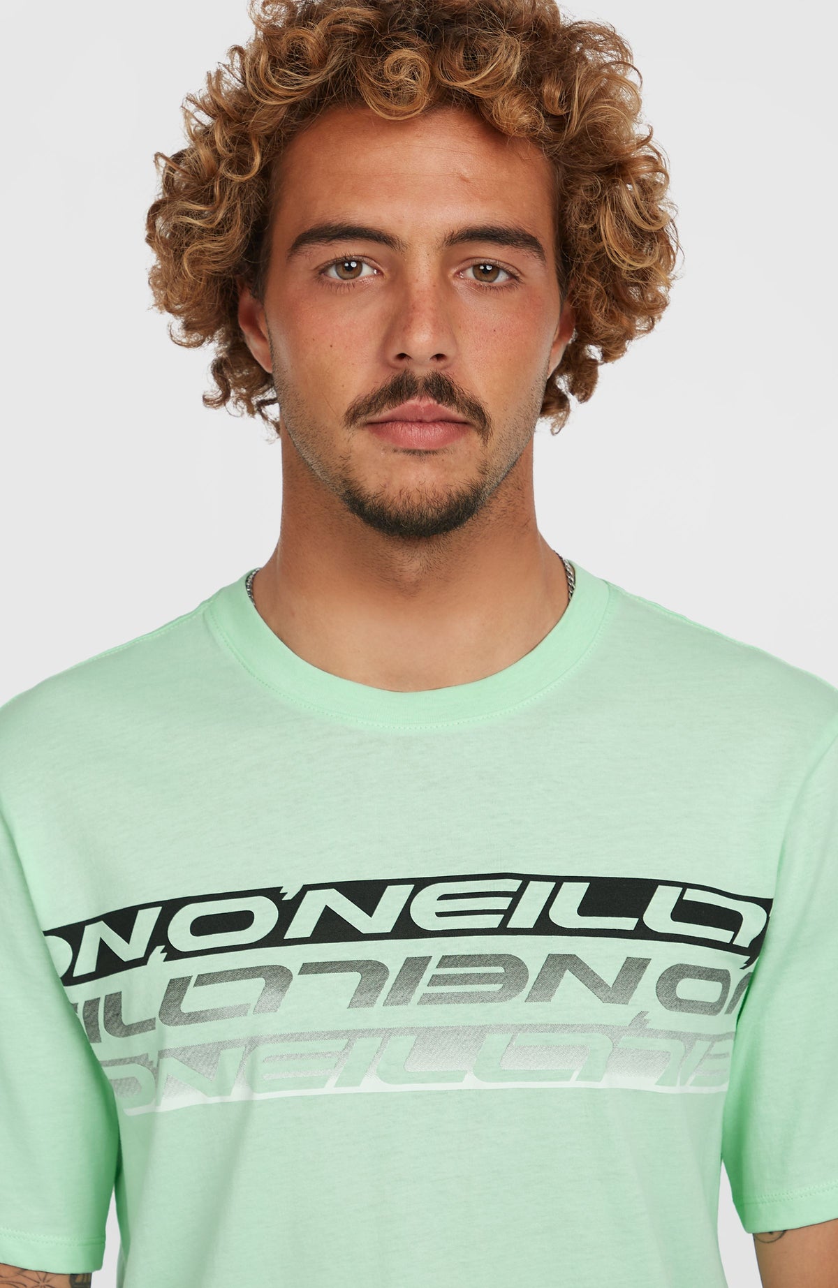 Nahaufnahme von Rundhalsausschnitt und Logo-Print in Schwarz und Weiß des grünen Stripe T-Shirts