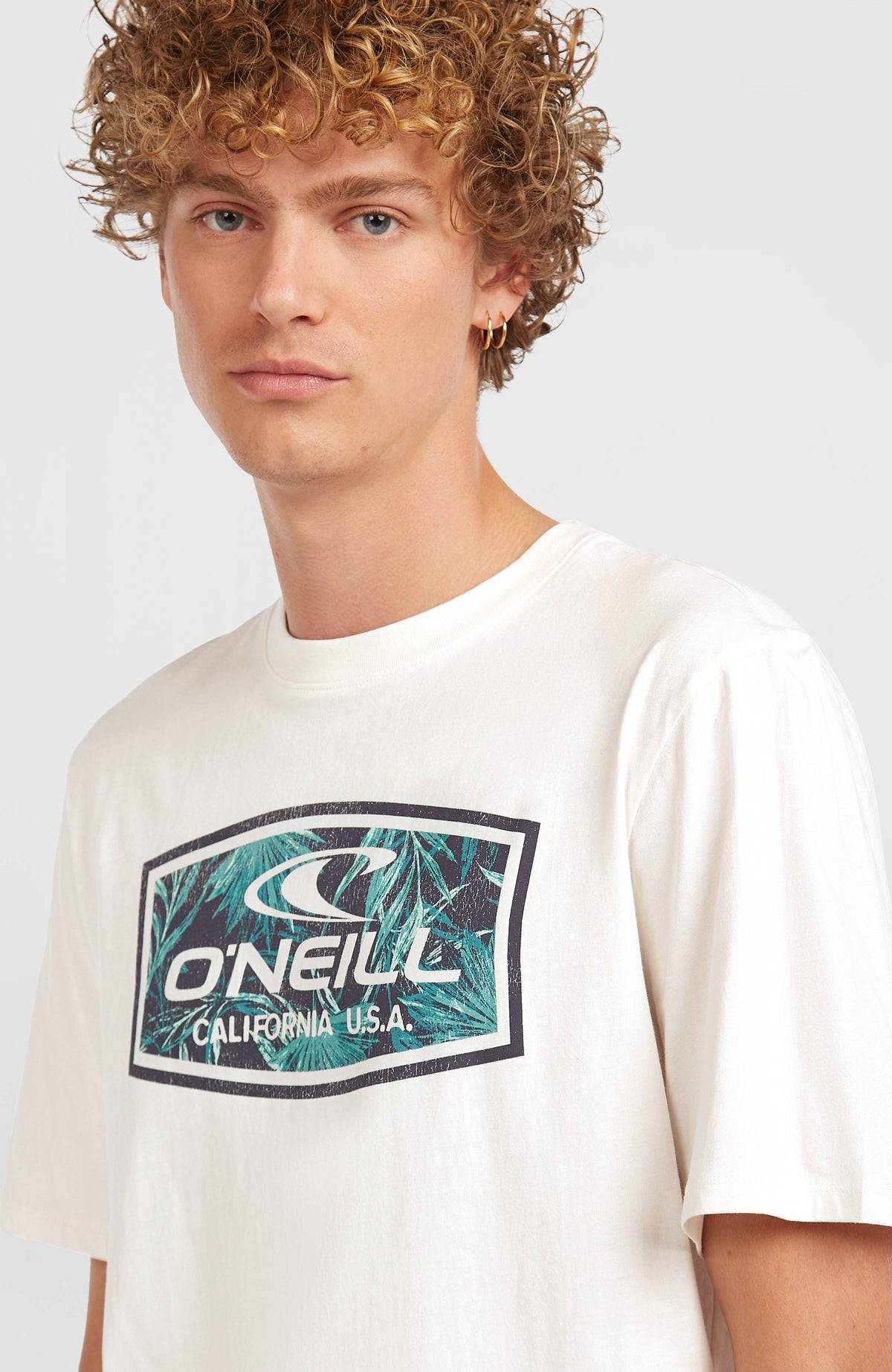 Nahaufnahme des Logo-Prints auf der Vorderseite des weißen Graphic T-Shirts am Model
