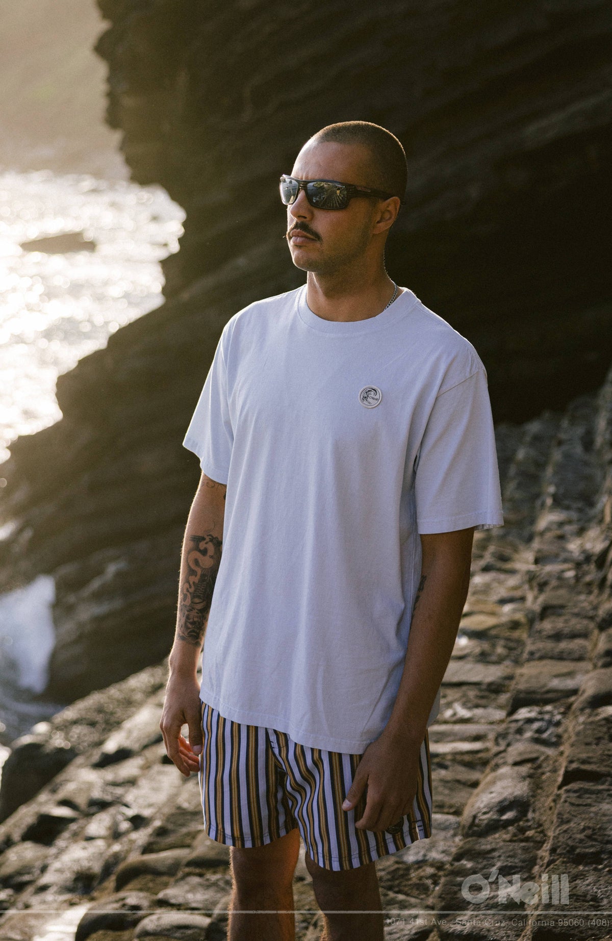 O'Riginals Vintage Graphic T-Shirt, blau, Vorderansicht am felsigen Ufer mit rundem Logo-Badge