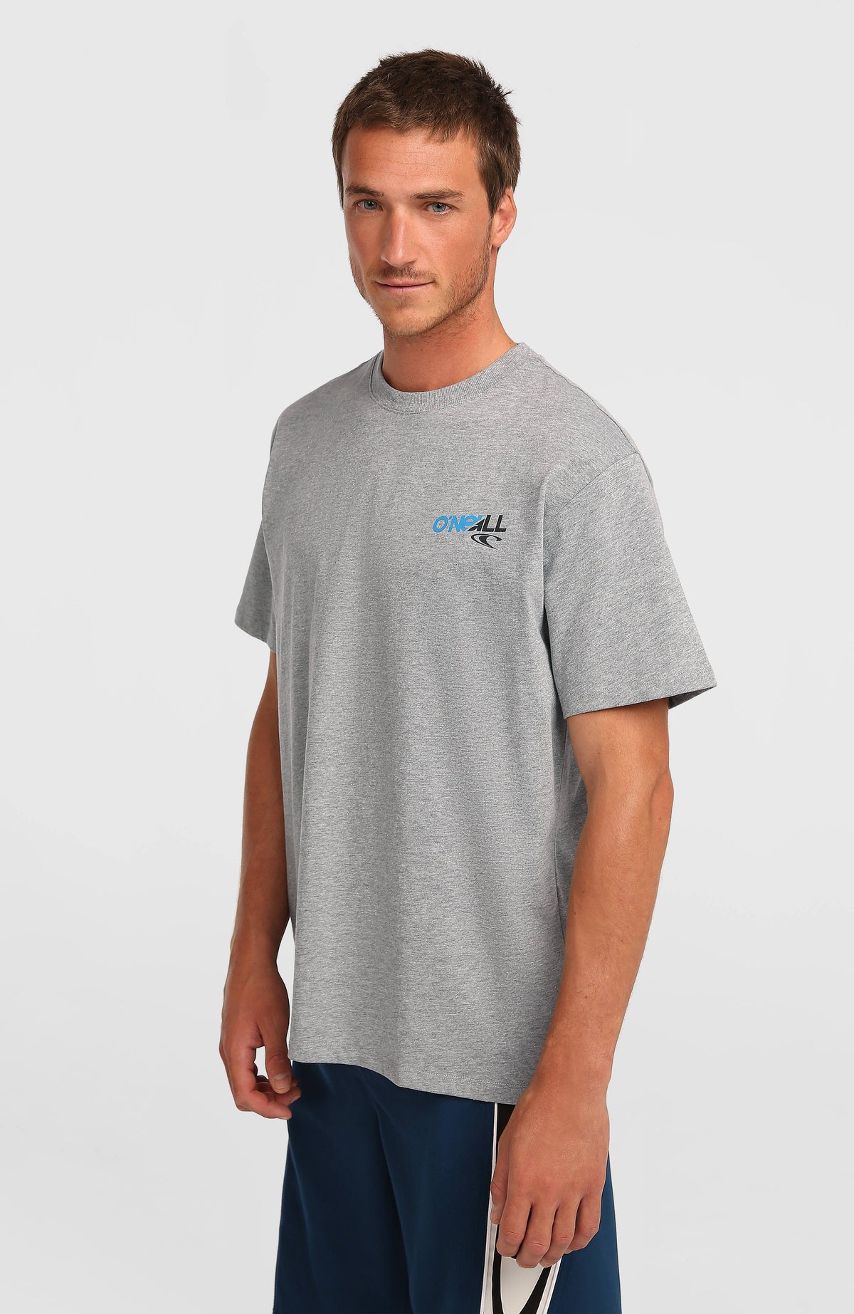 O'Neill Essentials 90s Graphic T-Shirt für Herren, grau mit Logo-Print in Blau und Schwarz, getragen am Model