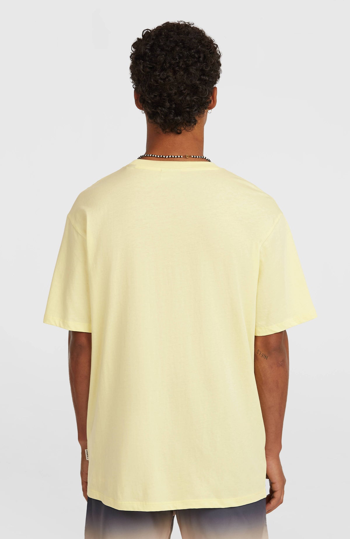 Muir T-Shirt für Herren, gelb, getragen am Model, Rückansicht mit kleinem Logo-Label an der Seitennaht