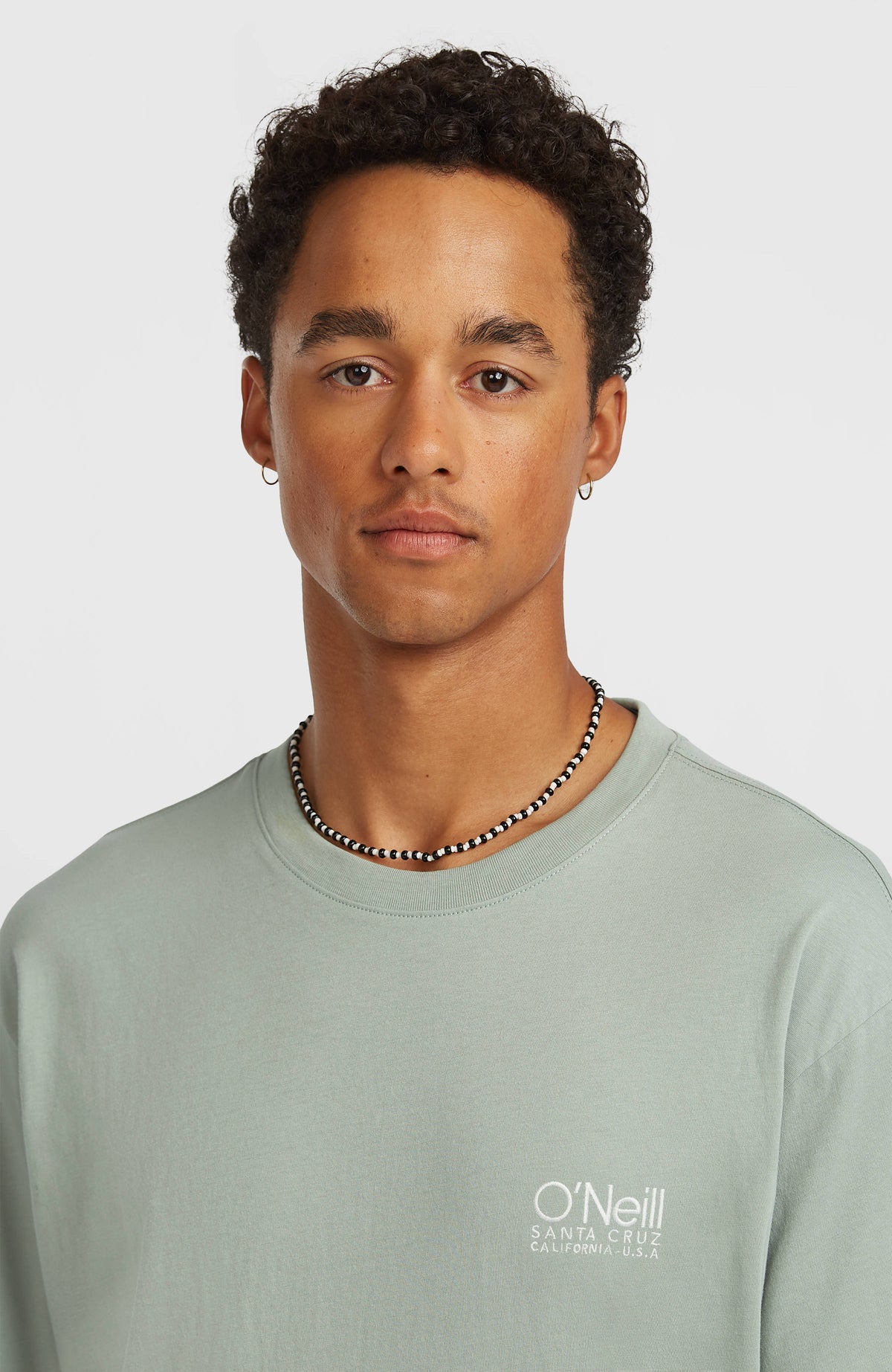 Original Cali T-Shirt für Herren, grün mit Logo-Print in Weiß, Nahaufnahme des Rundhalsausschnitts am Model
